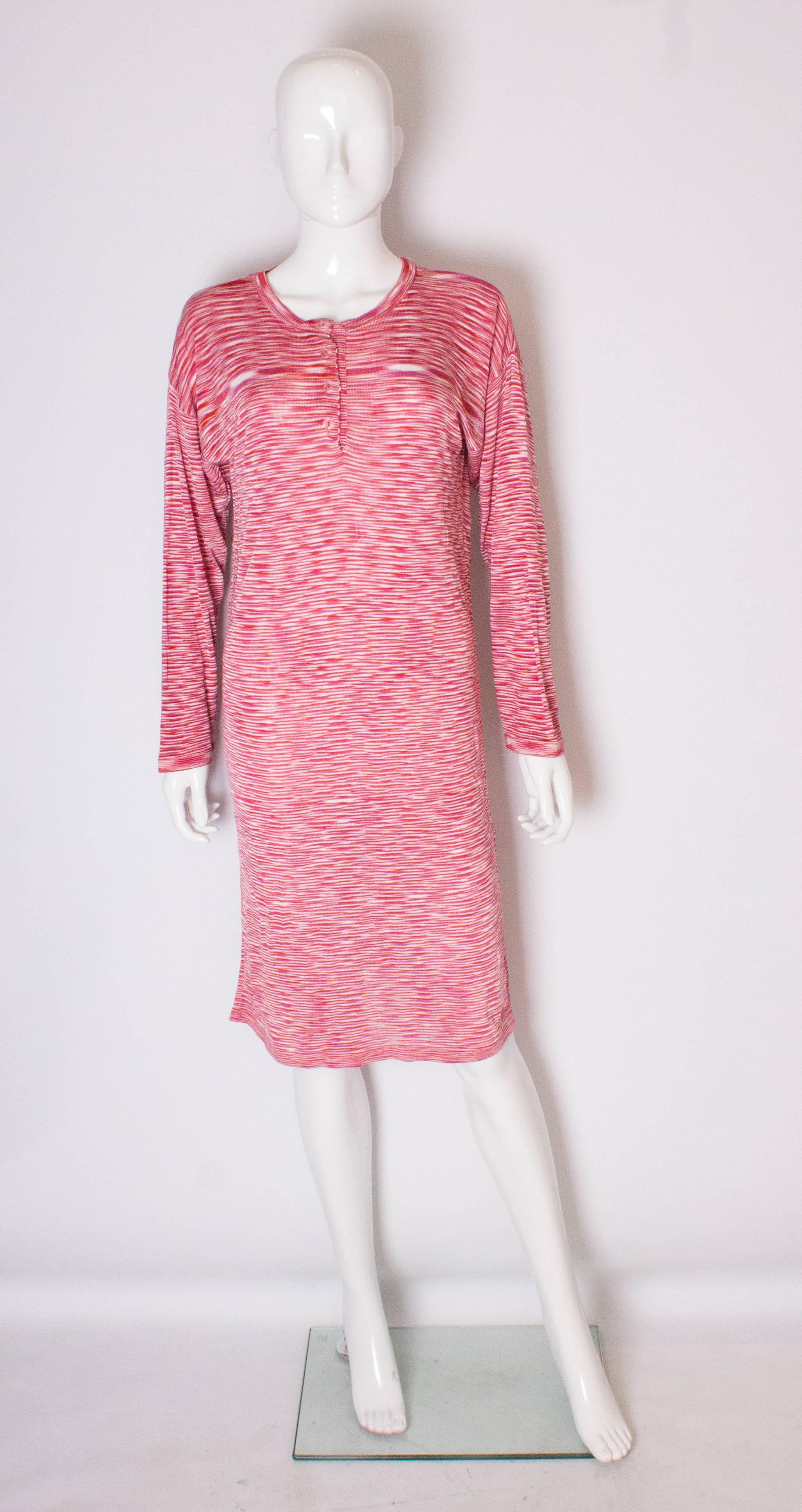 A chihc and easy to wear dress by Missoni.  The dress is in shades  of red and white. It has a round neckline with  a  four button opening.