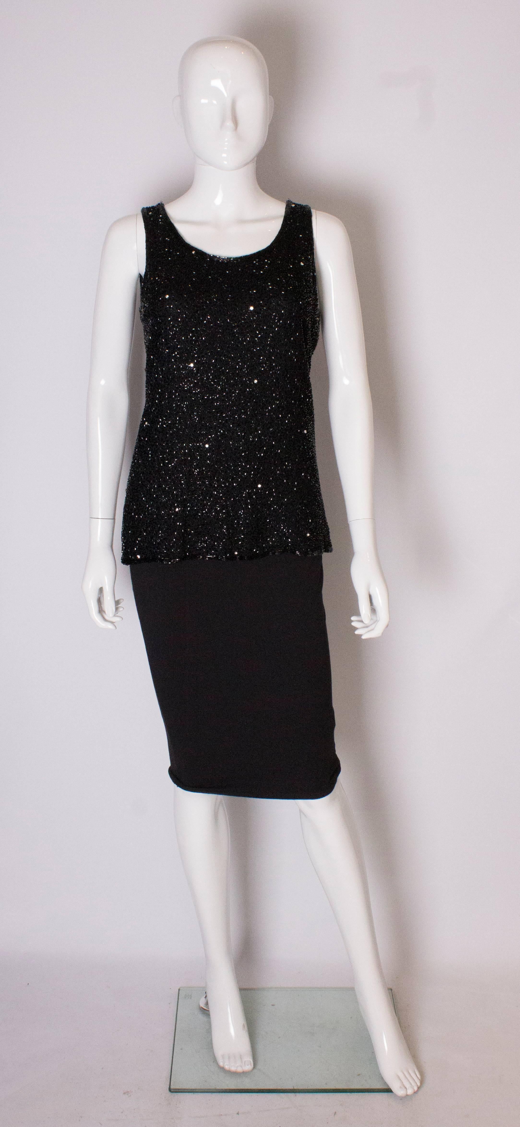 A chic vinttage  top by Tomasz Starzewski. The top has a scoop necklline and is sleaveless. It is covered with black beads and diamante stones .It has a central back zip, is fully lined and has 4'' slits on either side..