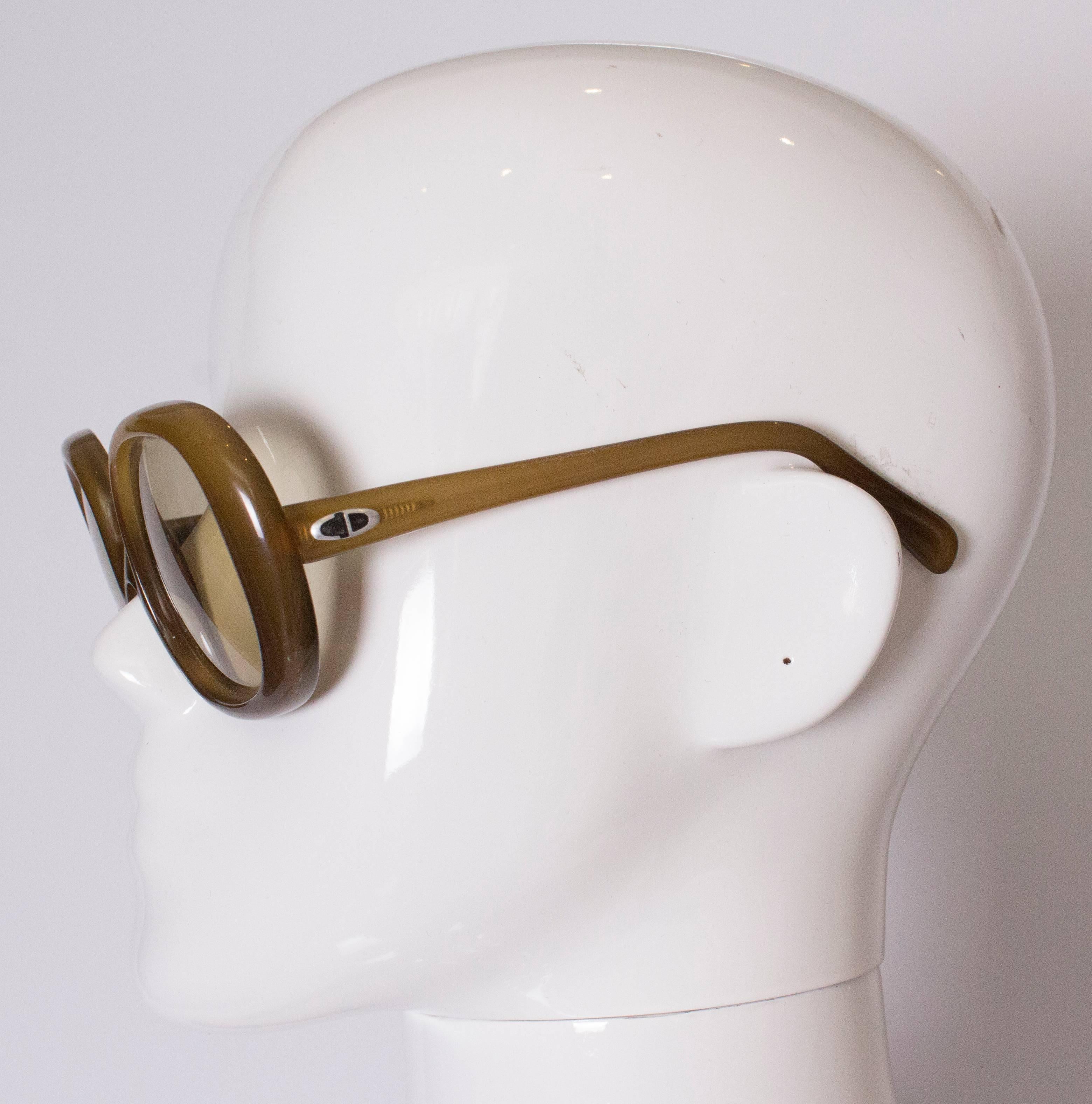 A chic pair of 1970s Christian Dior sunglasses. These glasses have an olive cloured frams.