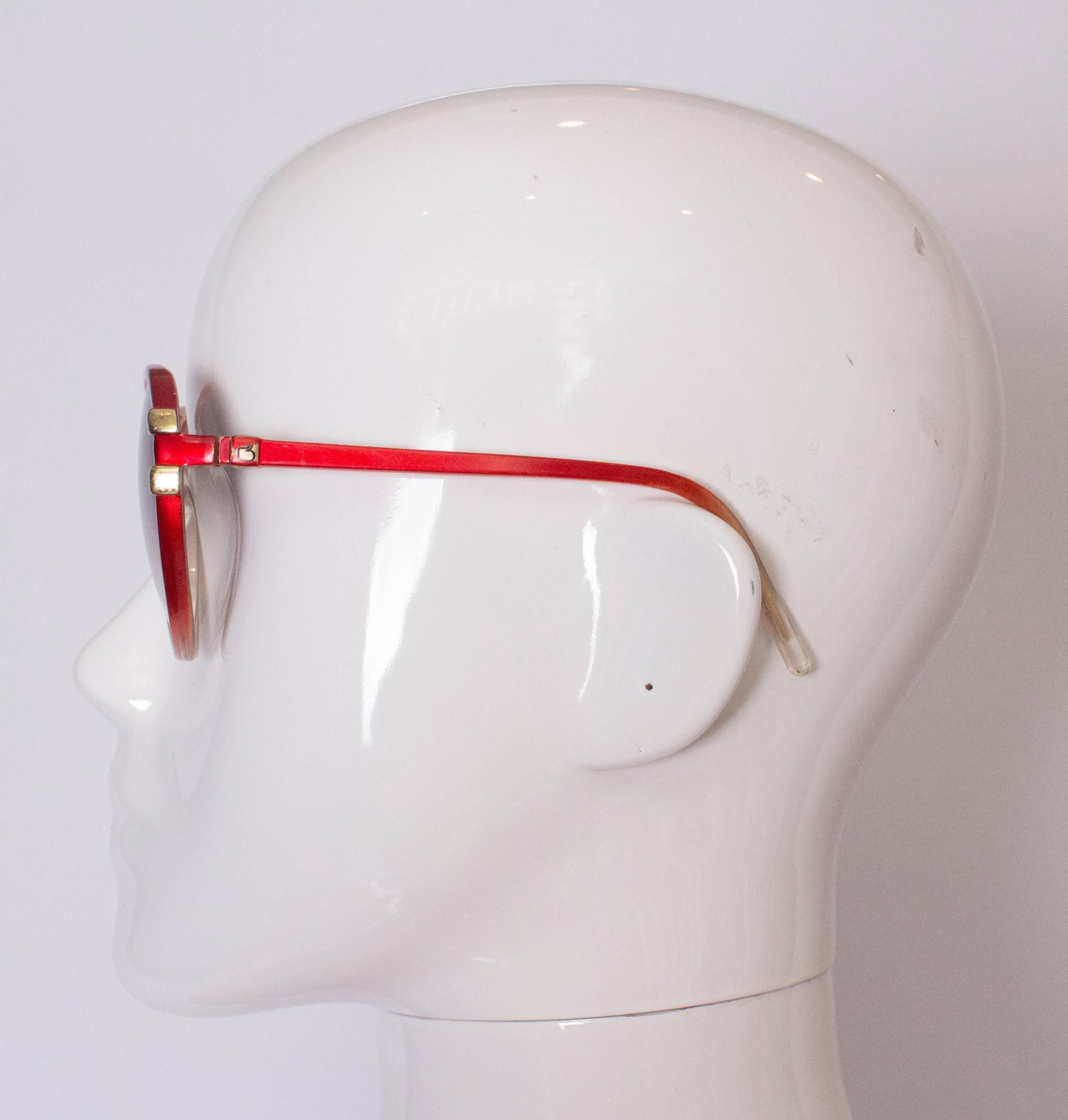 A chic pair of 1970s  sunglasses by Paola Belle, France. The glasses have red and ivory  frames and are number 6413RO.