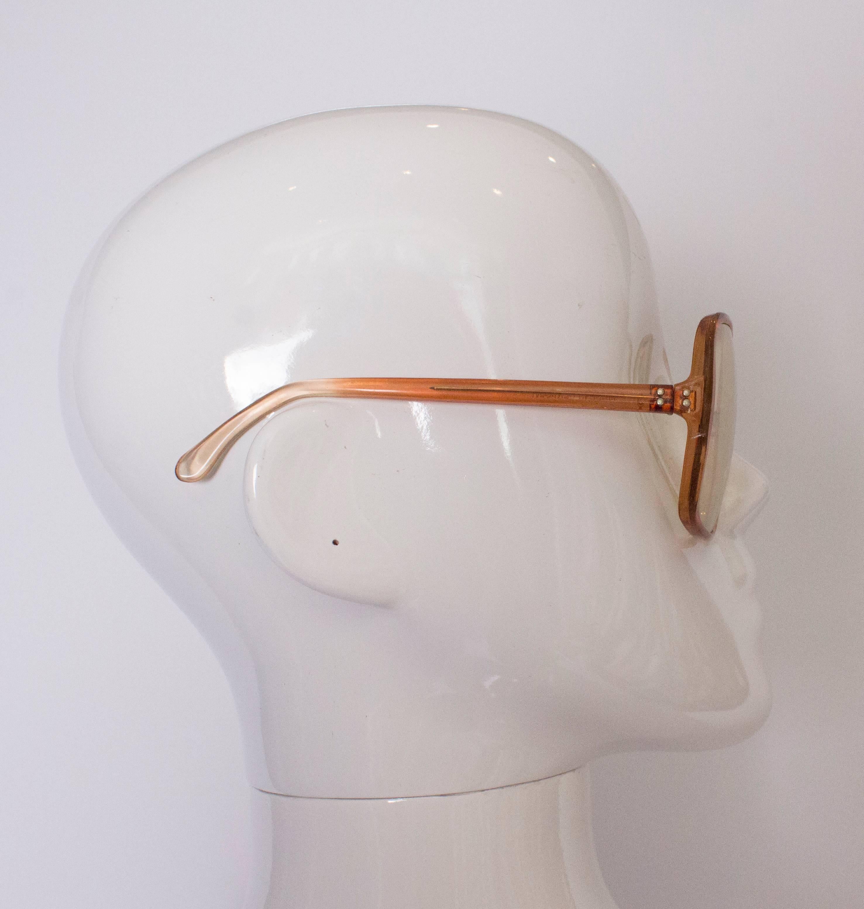 A great pair of 1970's sunglasses, they have a bronze /red colour frame and slightly tinted lense.