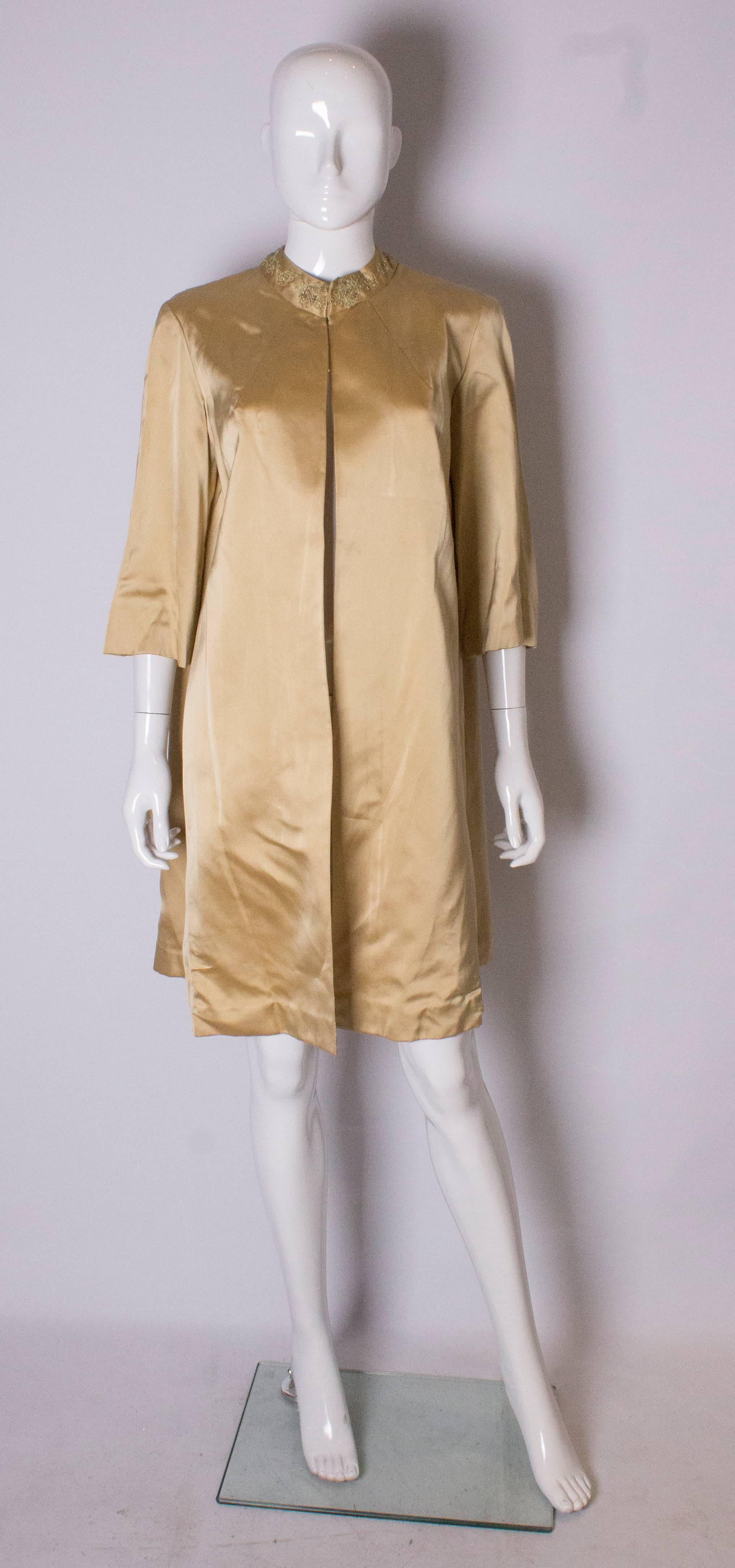 A great vintage duster coat for Spring /Summer. This gold satin  coat has an embroidered collar, is loose fitting , and can fit a bust up to 42''