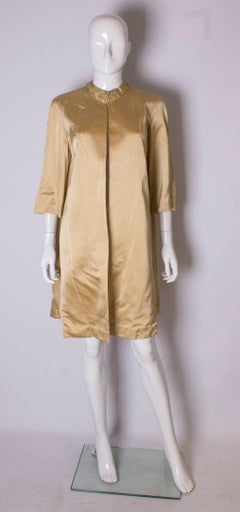 A Vintage 1960s Gold Saint Duster Coat by Carnegie