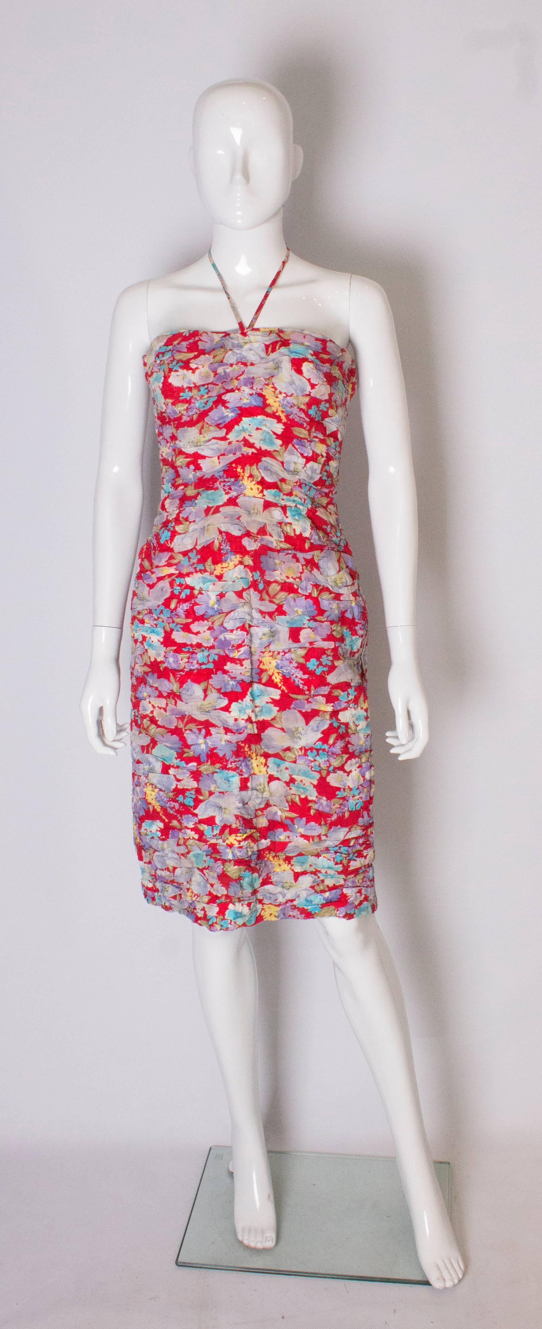 A super sundress for Summer. The dress is in a red fabric with a floral desgin. The dress has gathering over the bust  area, and a halter neck.