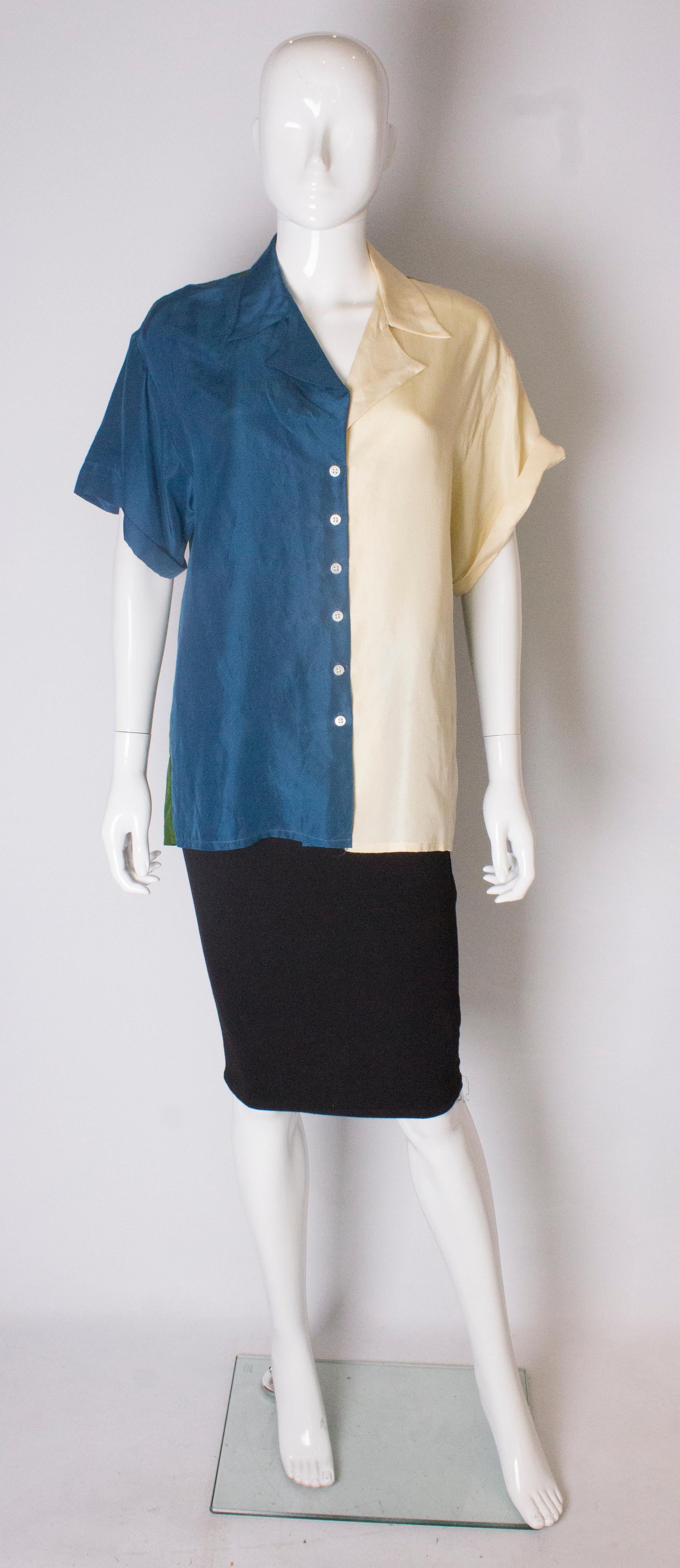 A chic silk shirt for Summer, in wonderful block colours. The shirt has a v neckline and front button opening. The back of the shirt is green silk, and the front  is blue on one side and cream on the other. 