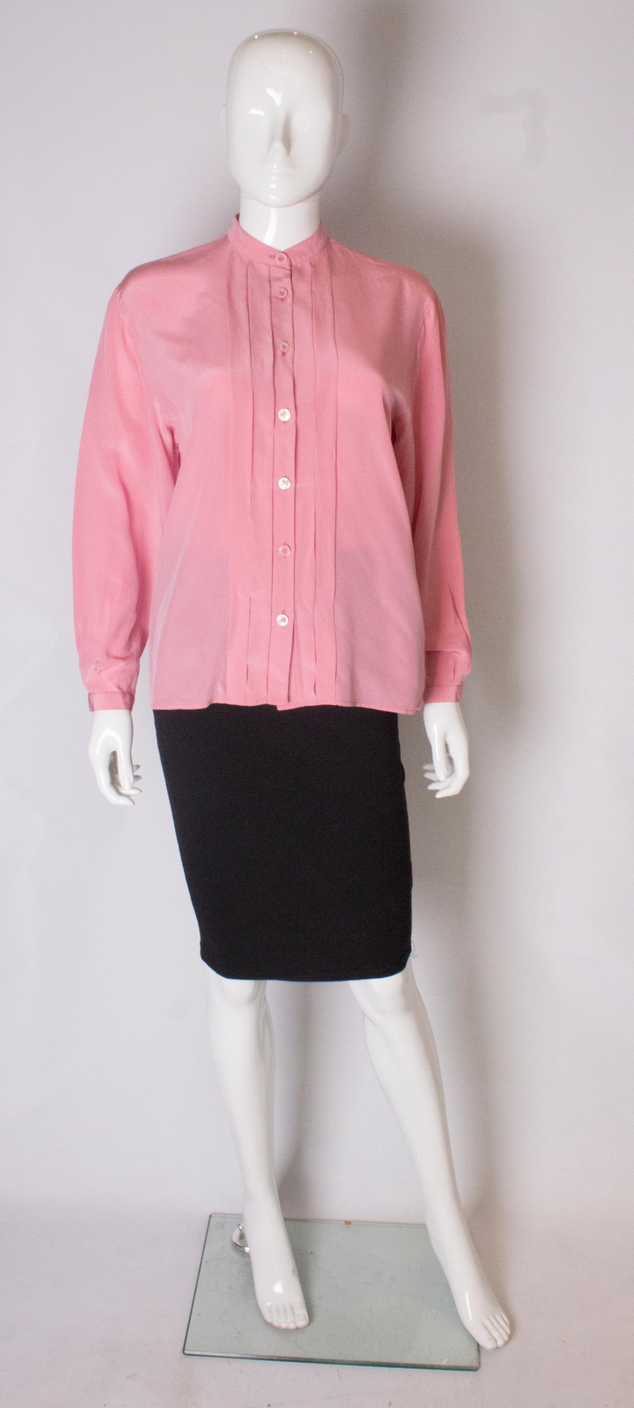 A pretty pink silk vintage blouse by Yves Saint Laurent,  Rive Gauche line. The blouse has central pleats on the  front and back and single button cuffs