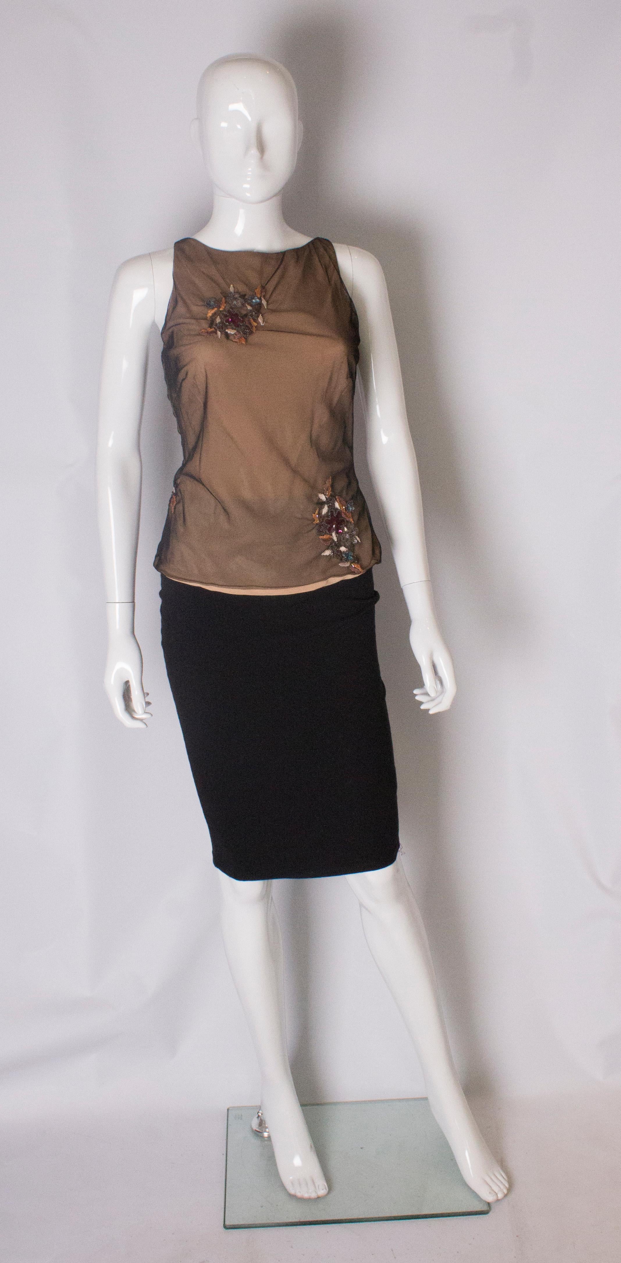 A chic top by Ben de Lisi, main line. The top is sleaveless with  a black net overlay ,and embellishment on the front and back. It has a tie opening at the back.