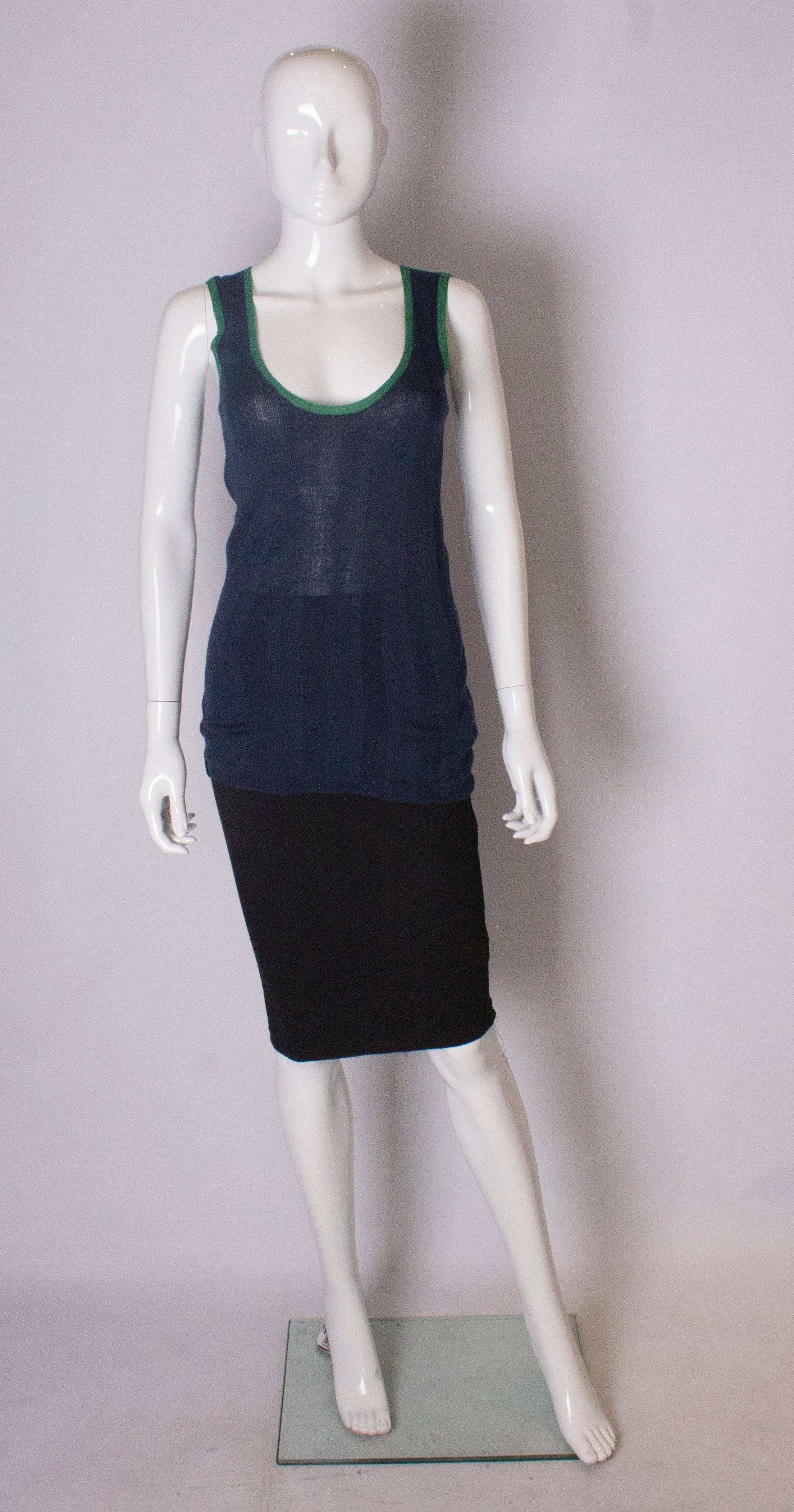  A chic top by Yves Saint Laurent. The top is in a silk mix, 53% silk, 42% cotton and 5% cashmere, an ideal weight for summer. In a navy blue ribbed knit with green trim this is a chic addition to any wardrobe.