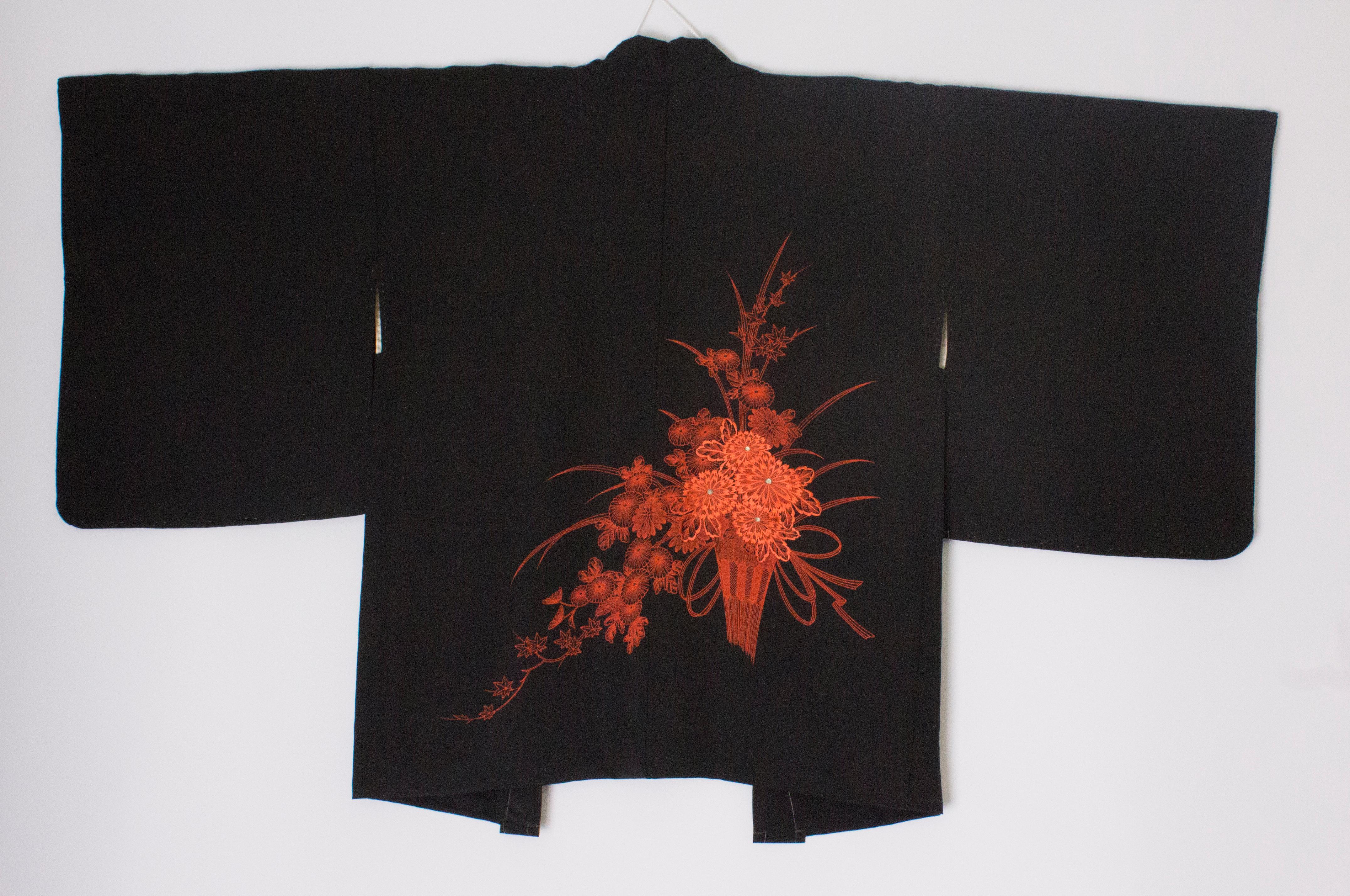 Un court kimono noir avec de magnifiques  détail de la broderie sur le devant. La partie supérieure est doublée d'un  un joli ivoire et un rose pâle. Mesures, buste jusqu'à 40'', longueur 31''
