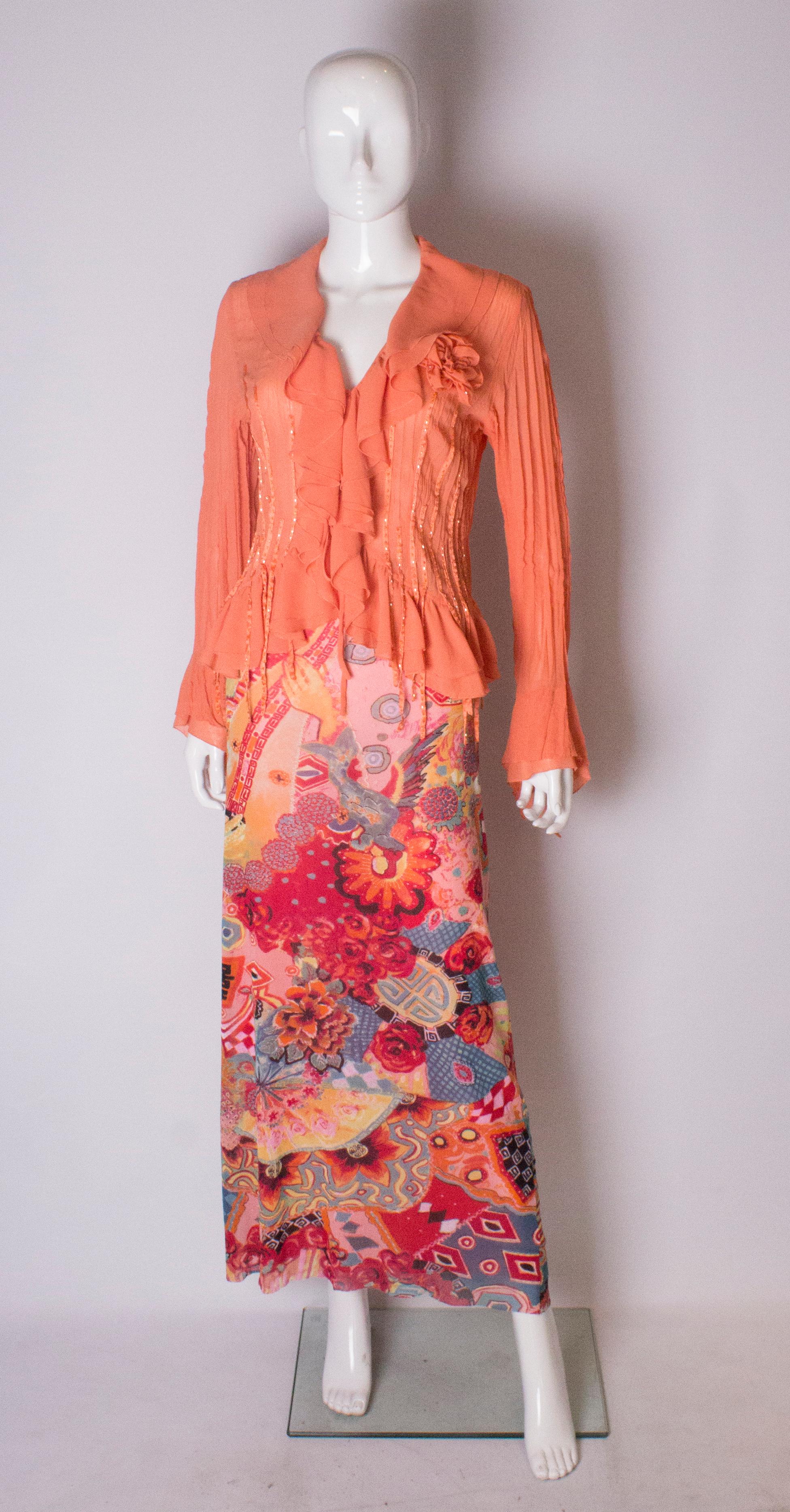 A stunning orange blouse by Claudia C. The blouse has a ruffle front with ribbon detail.
