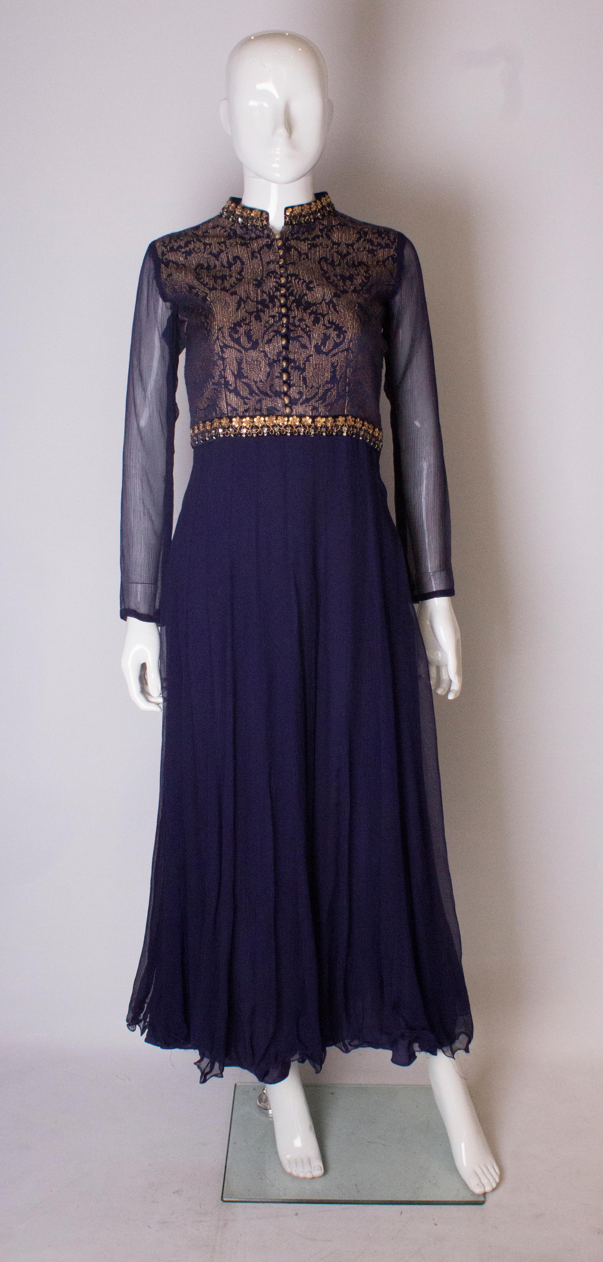 A stunning dress in silk chiffon and a brocade like fabric. The dress has a gold bodice, with fabric covered buttons, and braid detail. The skirt and sleeves are in silk chiffon. The dress is fully lined.