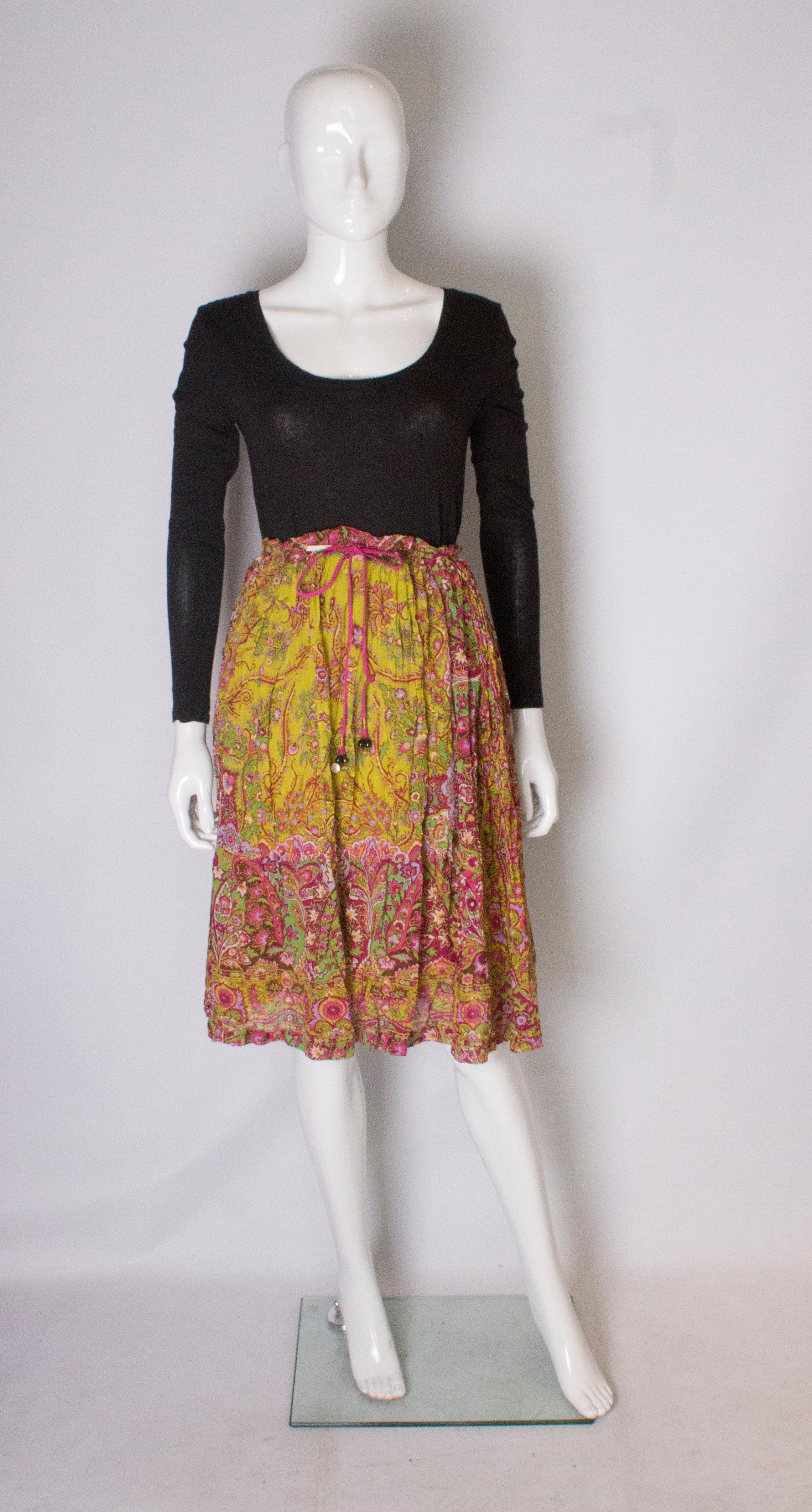 A pretty boho silk skirt by Etro Vintage. The skirt is in a pretty print with yellow, pinks,greens and browns,It has a drawstring waist with a pink silk tie and is fully lined in a mustard colour silk.
