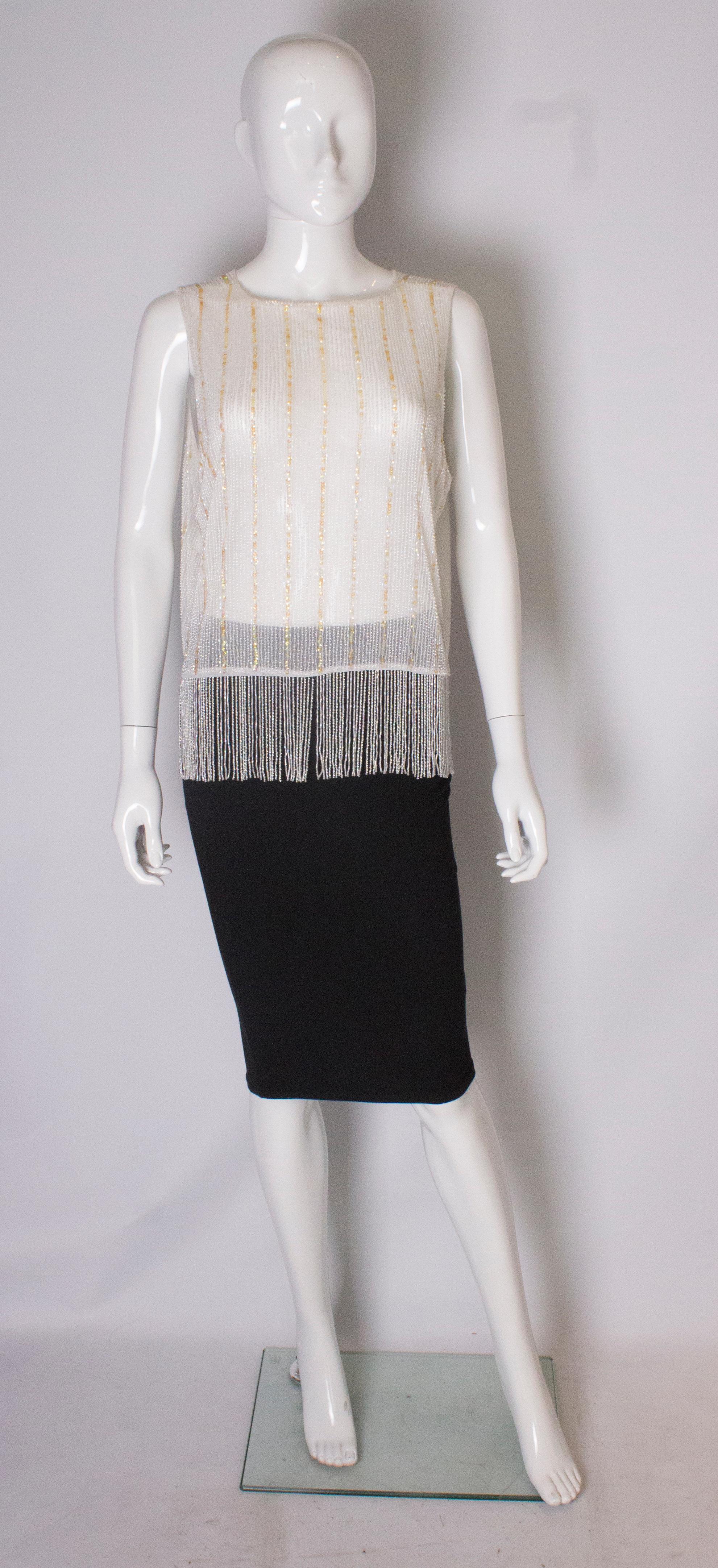 A chic and easy to wear top , made up of white beads with vertical lines in gold sequins.
The top measures , bust up to 37'', length 19'' with out fringing ,and the fringing adds an additional 5 ''.