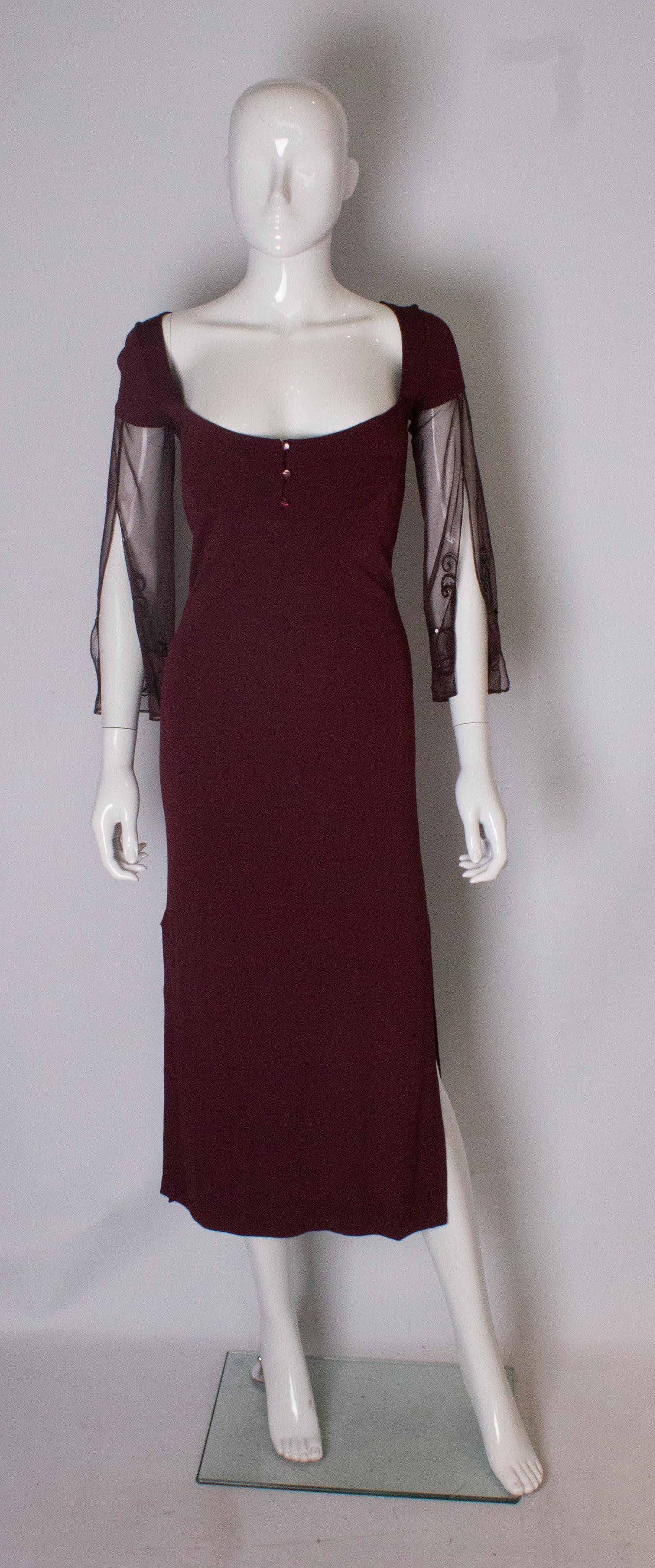 A chic dress by Obzek. The dress has a scoop neckline with three button detail, cap sleaves in fabric and then embellished net on the remaining part. The dress has  a 16' slit on either side.
