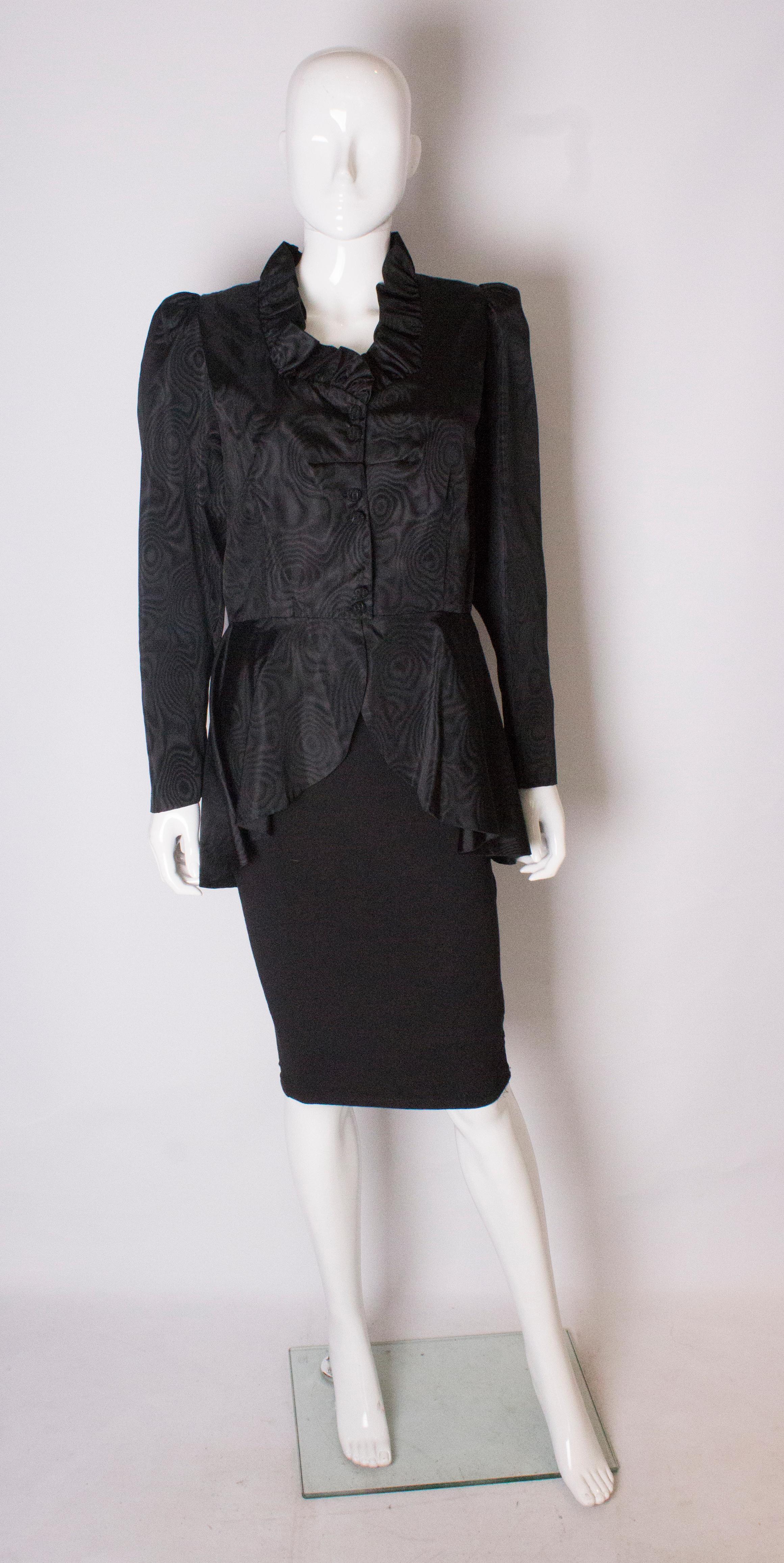 A chic black silk jacket . The jacket has a sweetheart neckline with frill trim, and a six button front opening, and two buttons on each cuff.
It has a wide peplum , and the length at the back is 33'' and 26'' at the front.