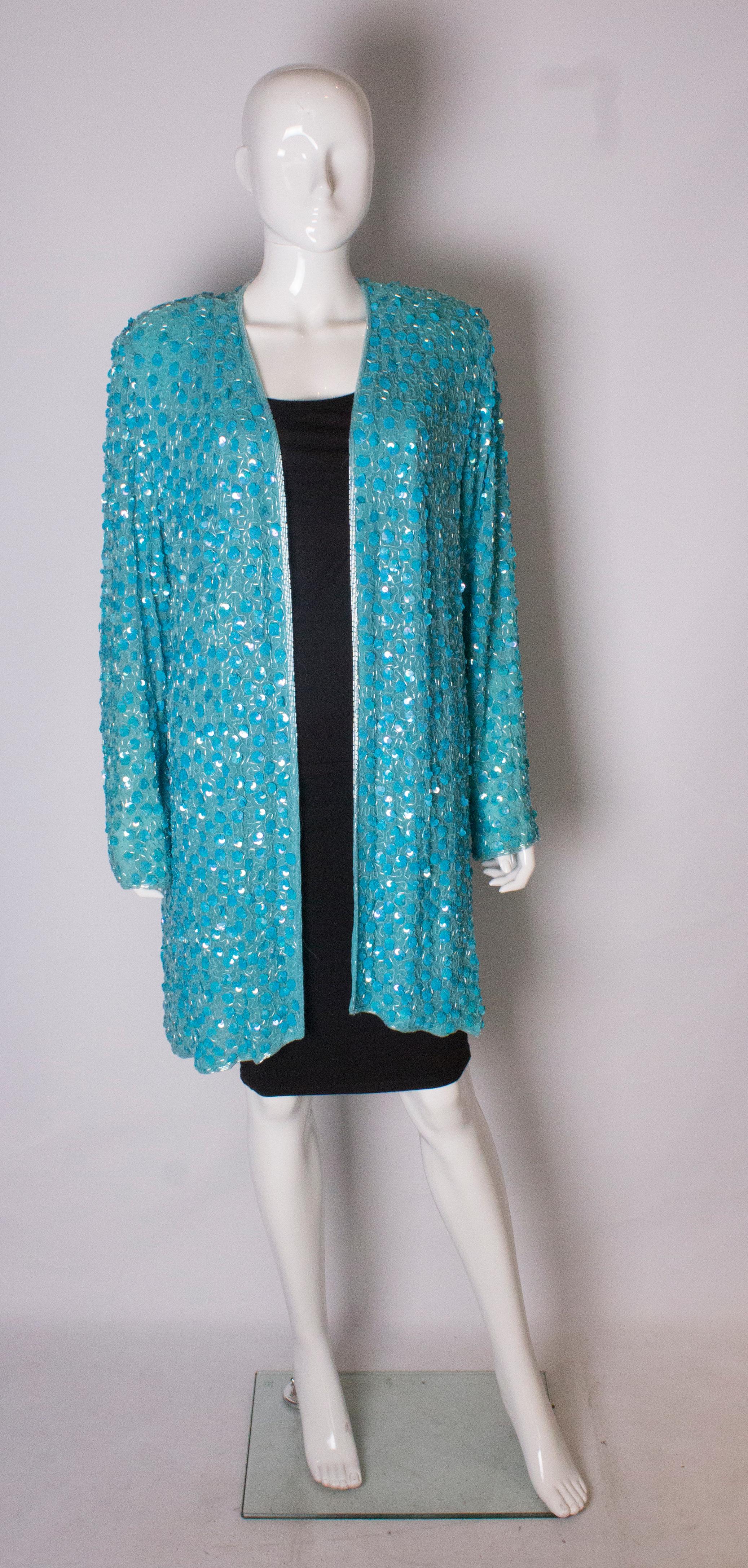 A pretty turquoise sequin jacket by Oliver James. The jacket is lined in silk , and the sequins are arranged as flowers .It is edged in beads, and has a v neckline. It is loose fitting and will fit a bust up to 42'', length 37''.
