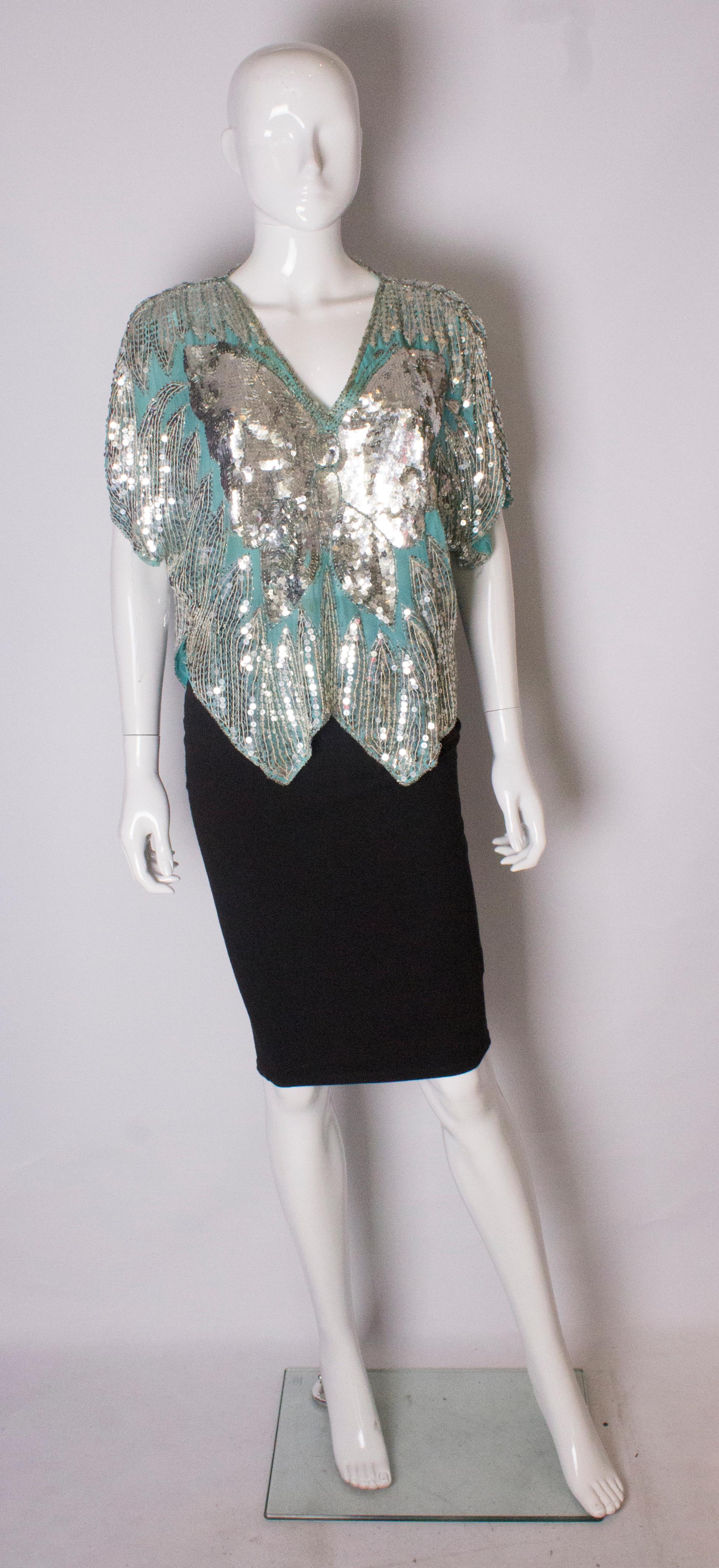 A groovy vintage butterfly top from the 1970s. The silver sequins are sewn onto a turquoise silk . The top has a v neckline, and is loose fitting and will fit a bust upto 49'',length 24''.