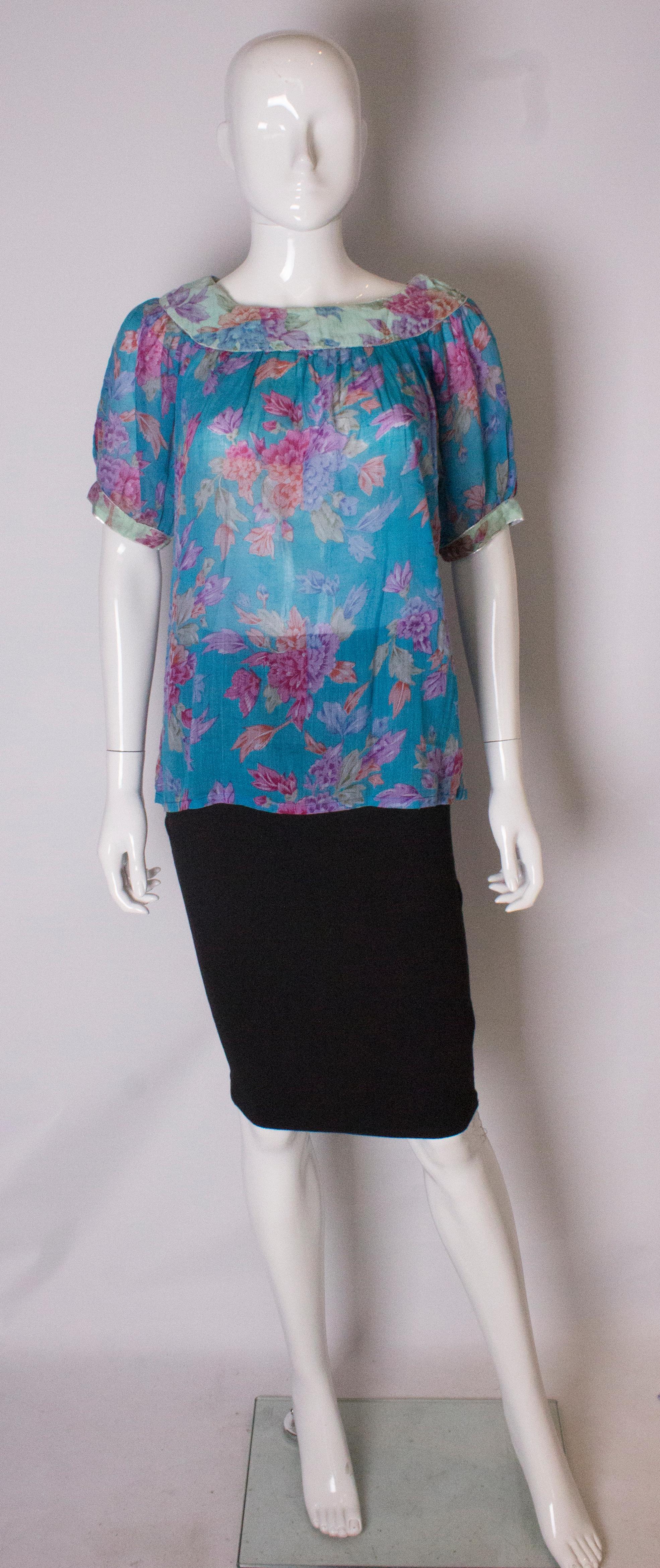 A pretty vintage cotton top by Phool. In a pretty floral print the top has a scoop neck with metallic trim, and puff elbow length sleaves with contrasting fabric.