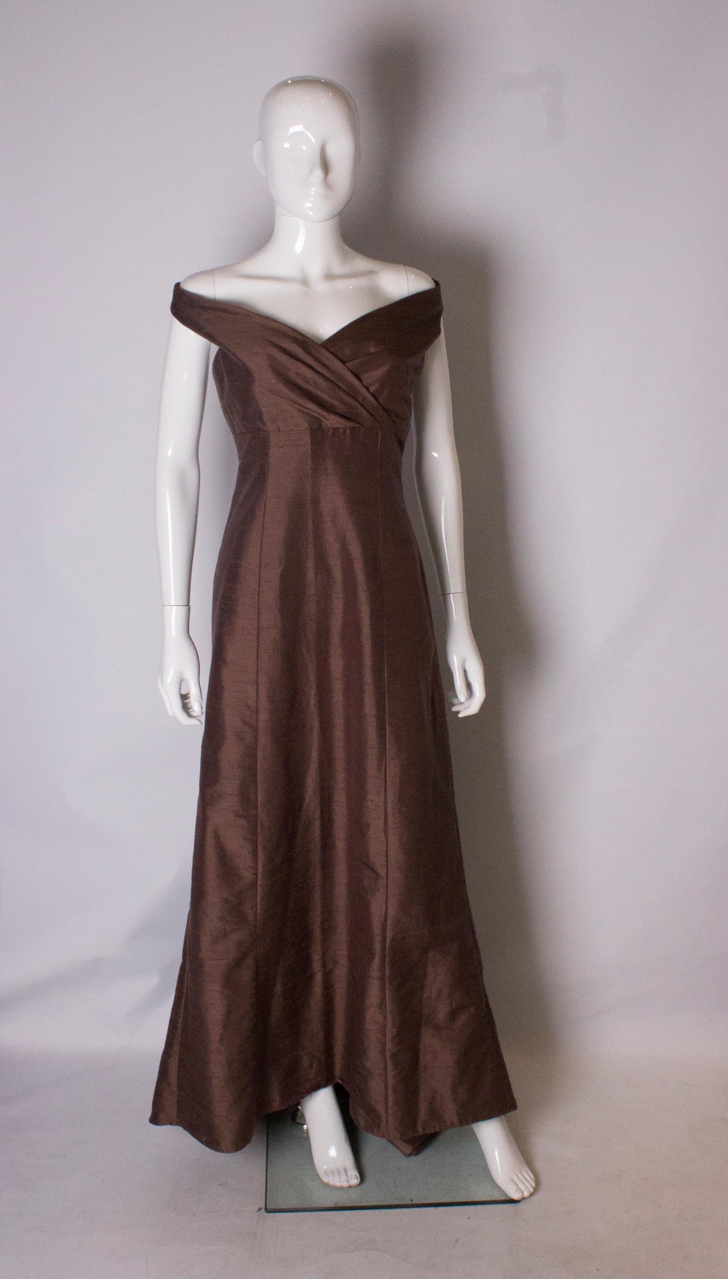Ein wunderschönes Vintage-Seidenkleid in einem hübschen Braunton. Das Kleid hat eine überkreuzte Vorderseite und ist leicht schulterfrei.
Es hat einen zentralen Reißverschluss auf der Rückseite, ist vollständig gefüttert und hat eine Pfützenschleppe.
