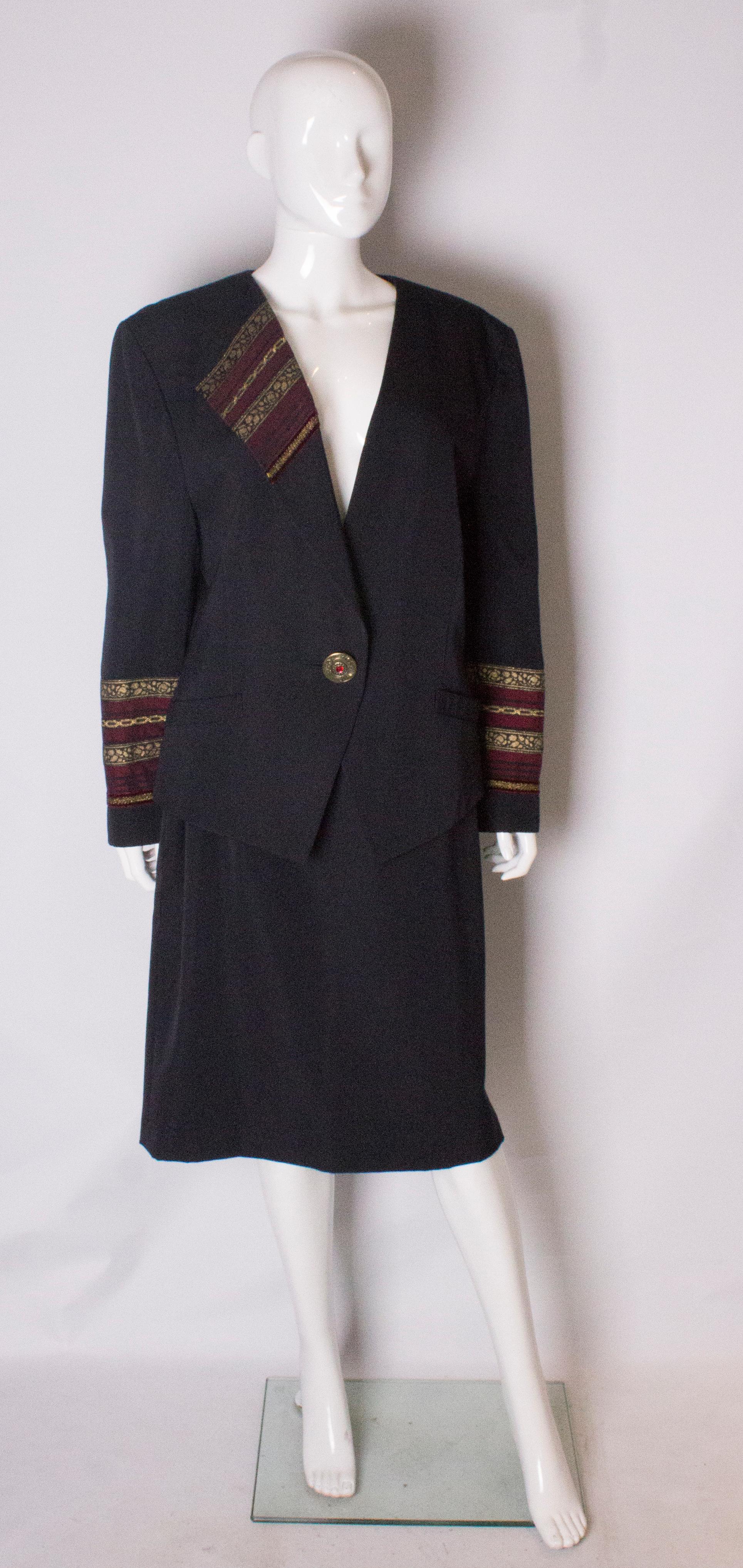 A chic and unusual skirt suit by Louis Feraud. The jacket has a v neck line with detail on one side and detail on the cuffs, and fastens at the front with one button.. The skirt has a decorative waist band and 7'' slit at the back . It is fully