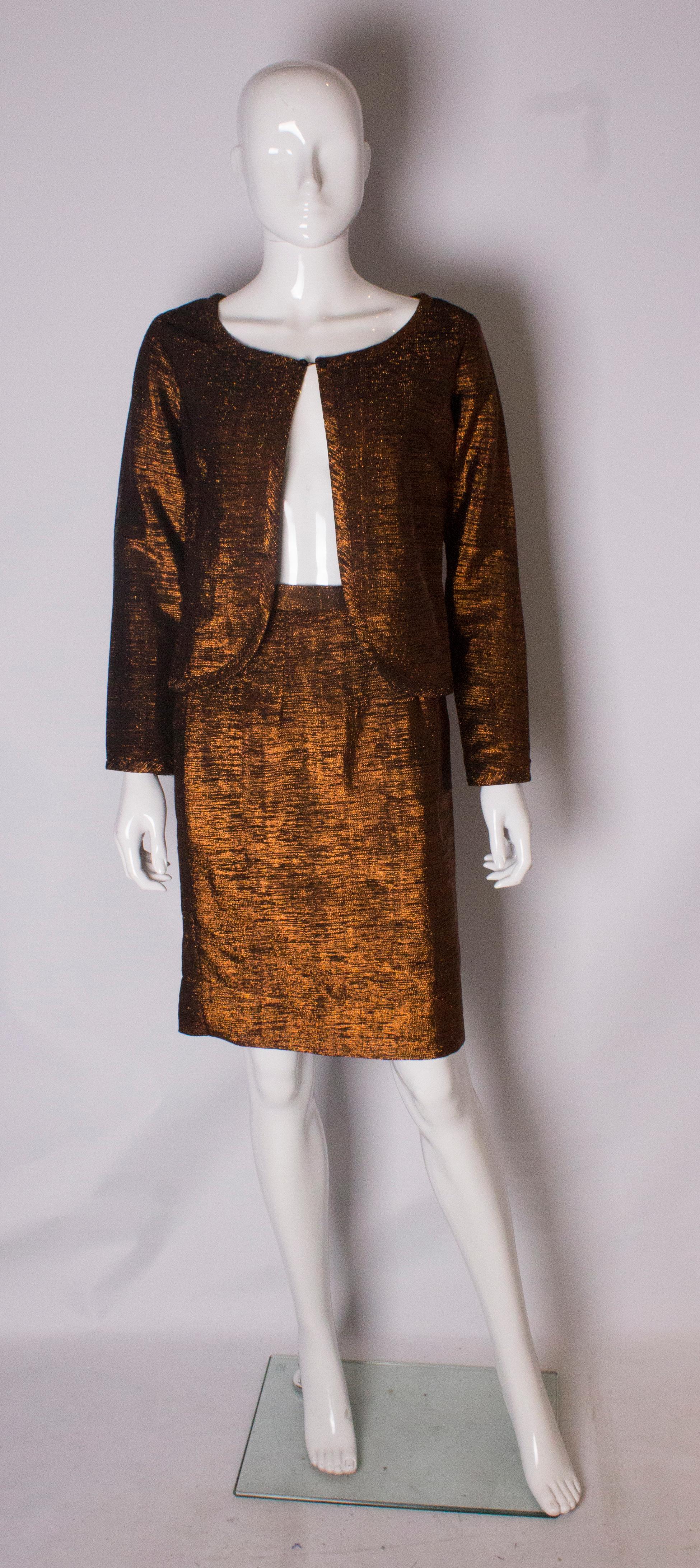 A chic and easy to wear cocktail suit in a bronze lurex. The jacket has a round neckline with fastening at the neck and a scoop hem. The jacket is lined. The skirt is fully lined and has a 3'' hem, should it need to be taken down.
Jacket bust