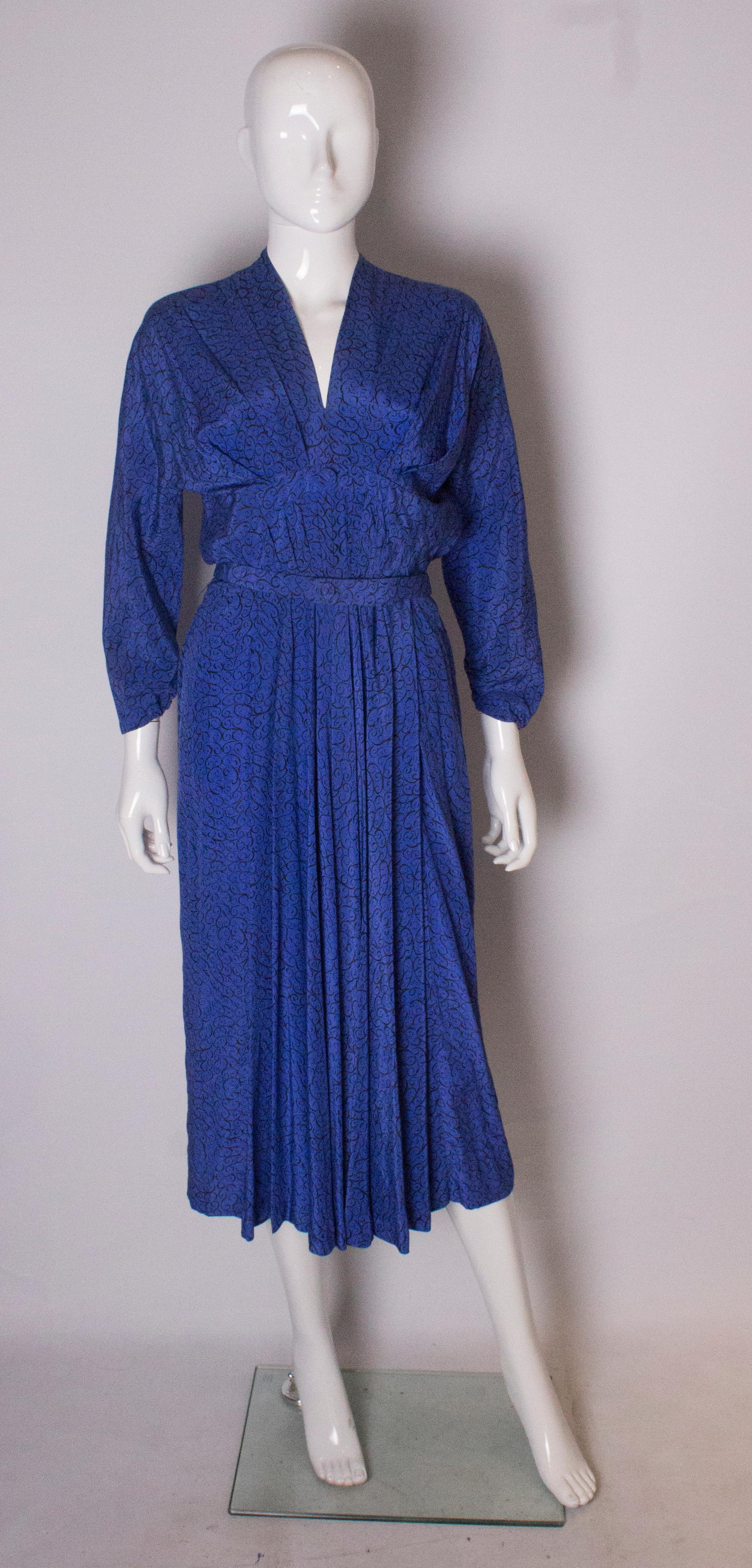 A great silk dress by Robell of Baker Street. This dress has a v neckline with pleats either side. It opens with a side zip and there is some boning , and an internal waist belt. The sleeves are elasticated with some gathering, and there is a self
