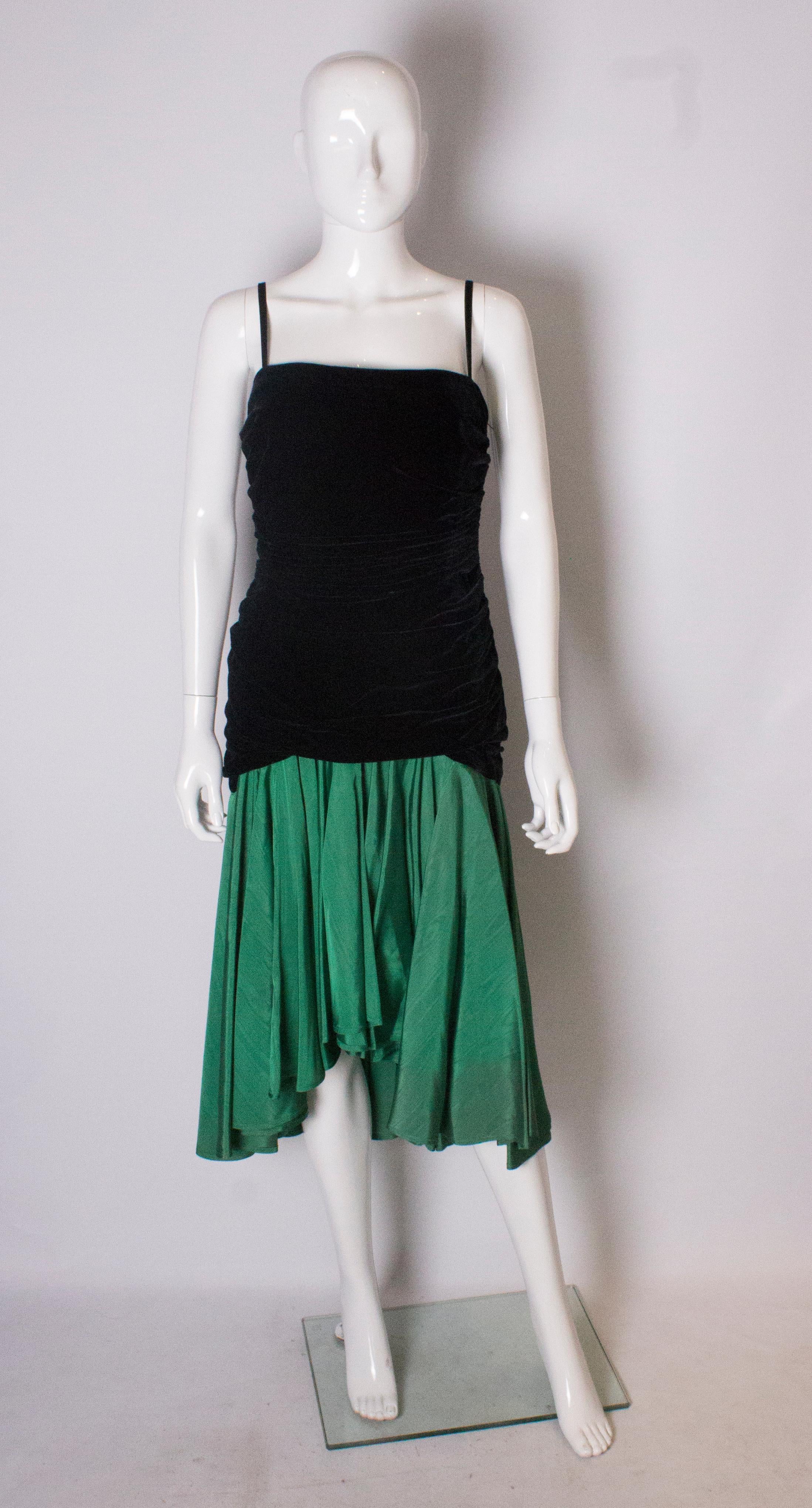 A chic vintage dress by Mimminia of Italy.  The dress has a black velvet bodice with spaghetti straps, and a side zip. It has a drop waist , and a skirt in green moire silk.