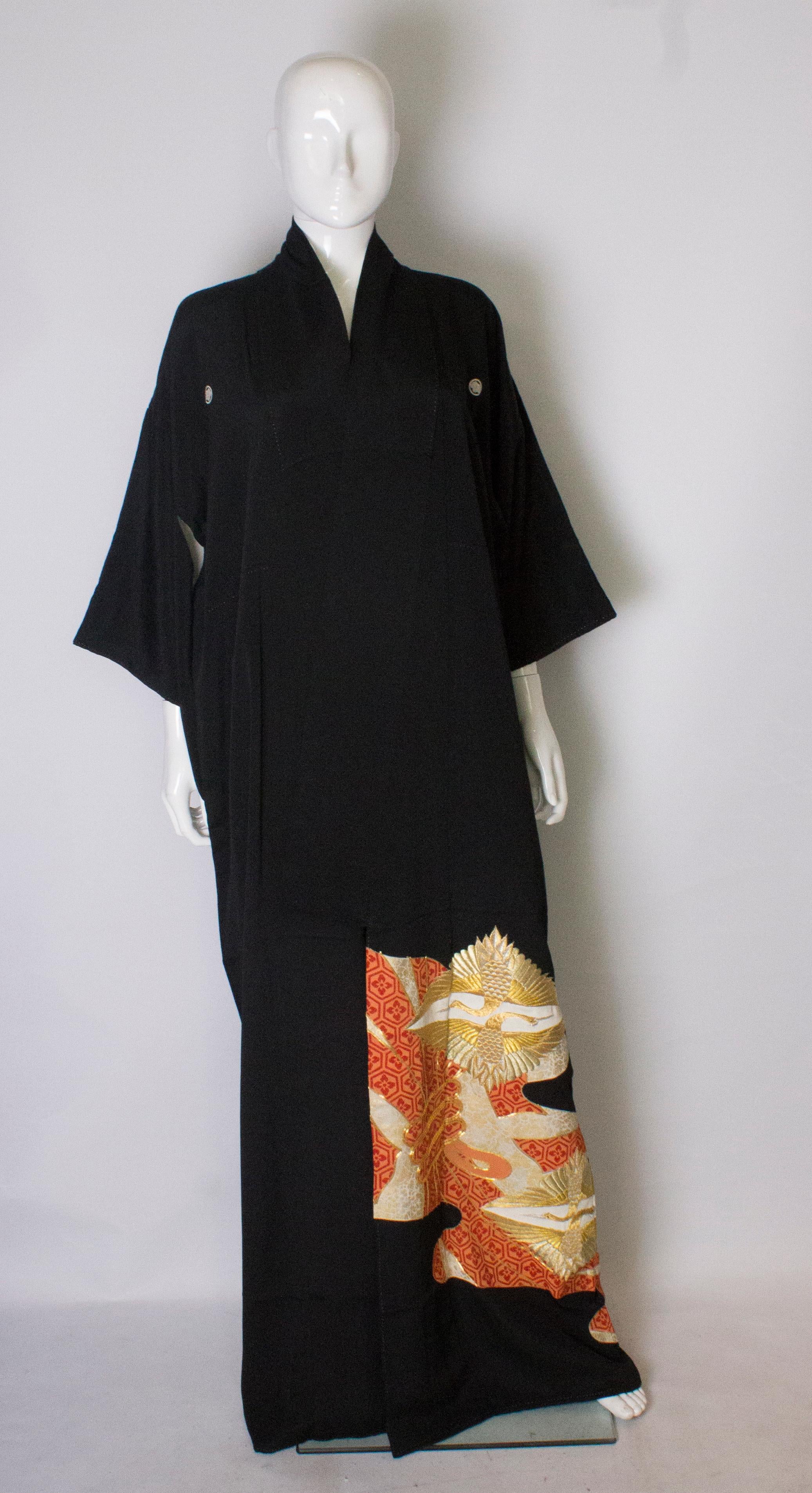 A stunning vintage black kimono with embroidered  gold dancing cranes.