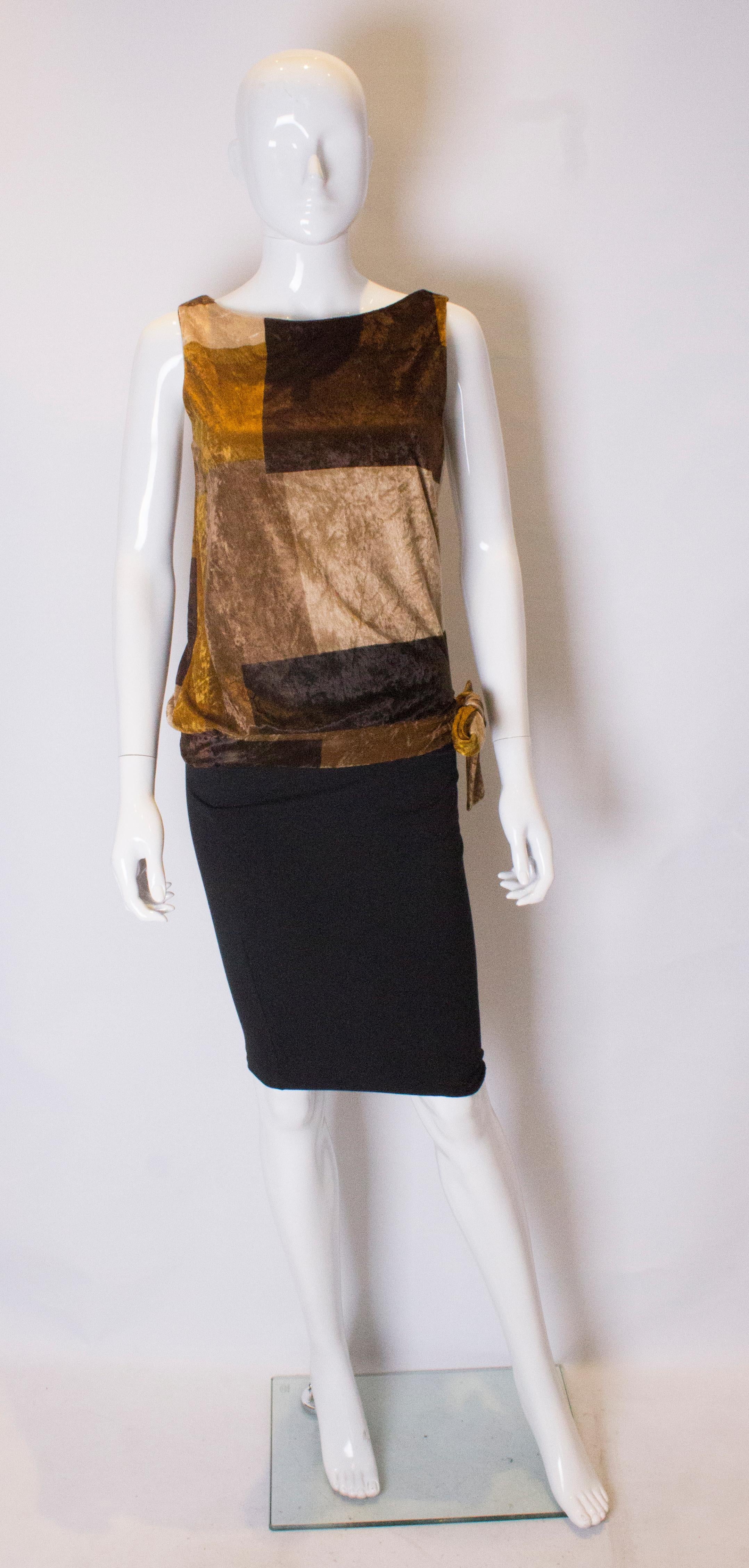 A great top for fall.  In a lovely light velvet , the top is in various shades  of gold and brown. It is sleaveless and ties at the waist on one side.