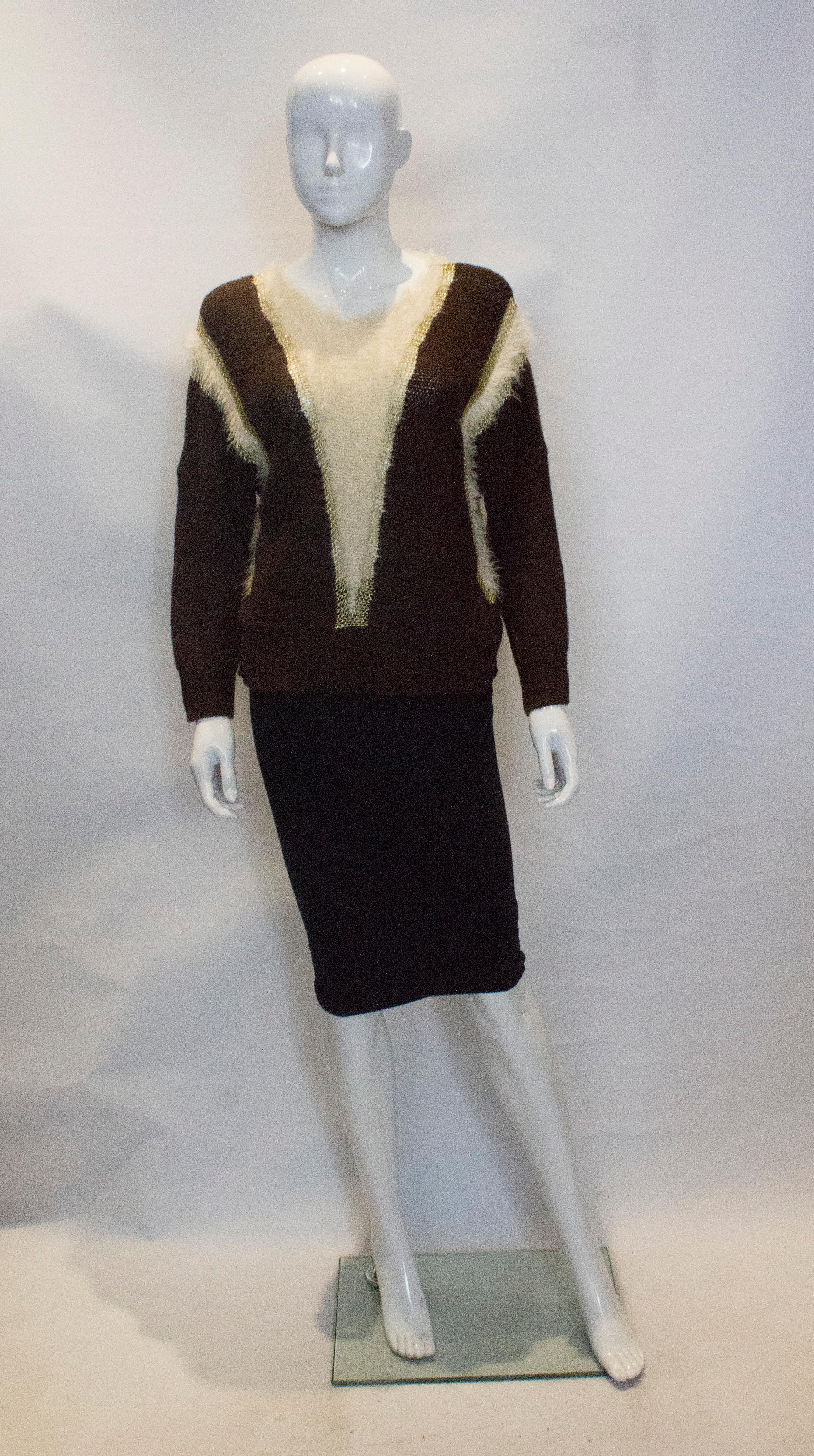 A great jumper for Fall. The jumper has a round neckline with drop shoulders. It has vertical lines of gold that lengthen the body and white knitted areas.