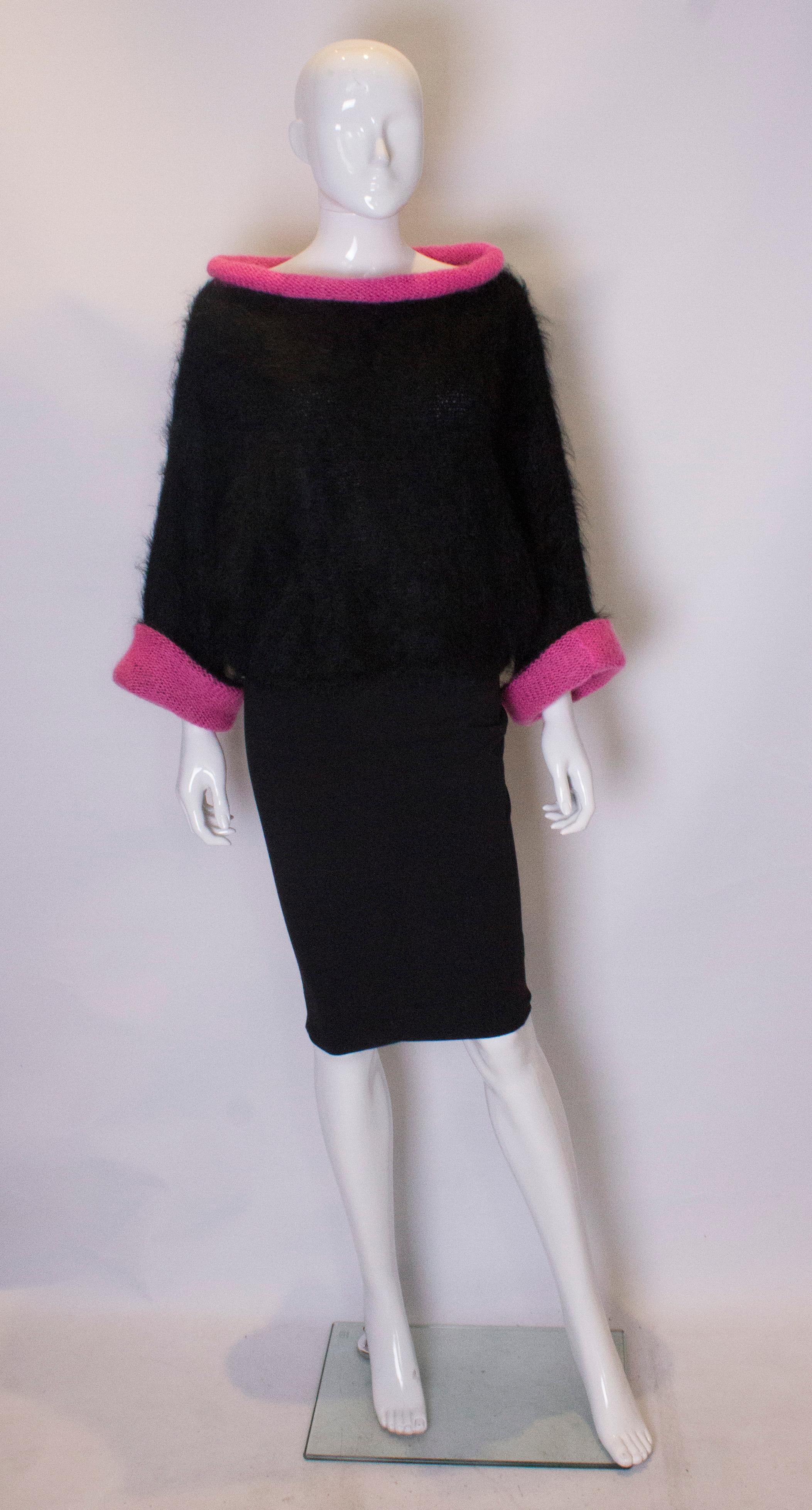 A chic pink and black mohair jumper. The jumper has a roll /slash collar with pink trim., and the lightly batwing  sleaves are edged in pink.