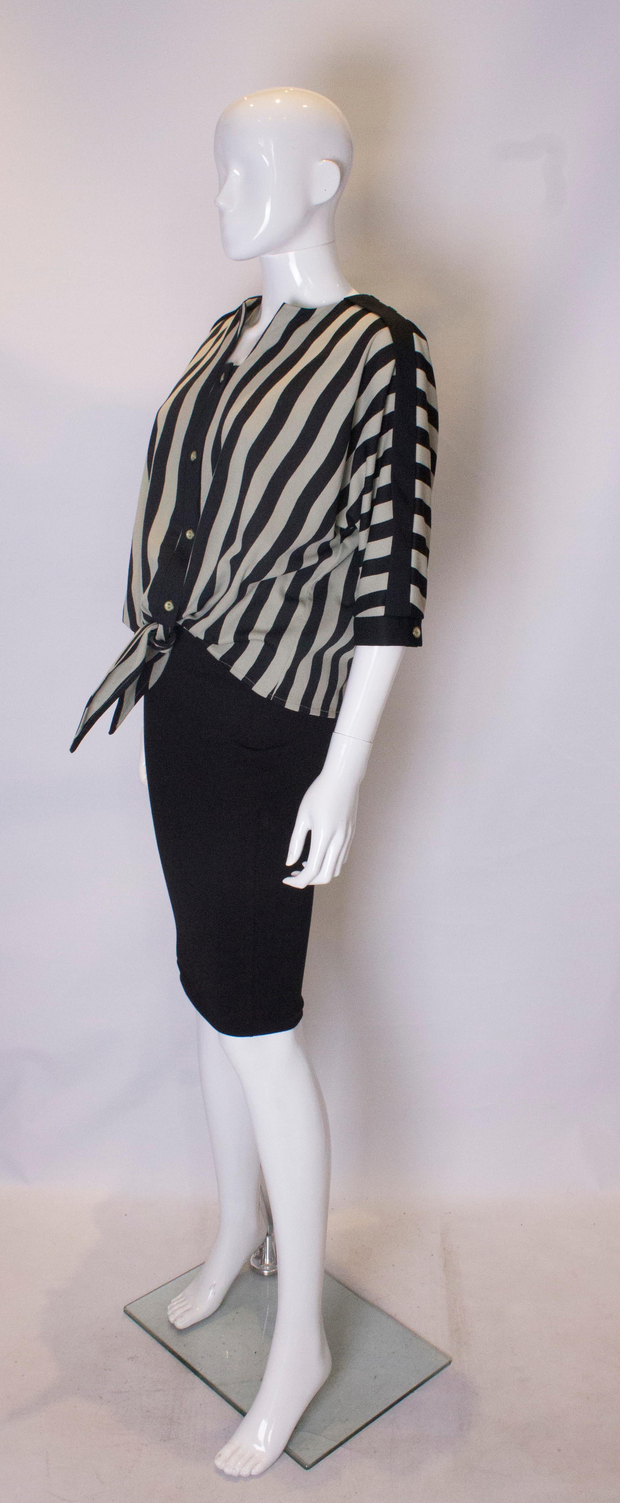 A chic vintage top by London Look. The top is in a pale green and black vertical stripe. It has great detail running on the length of the sleave and at the cuff.  The top has a four button opening, and tie at the front.