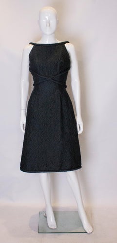 A vintage 1950s couture backless bottle green cocktail dress by Edward Abbort