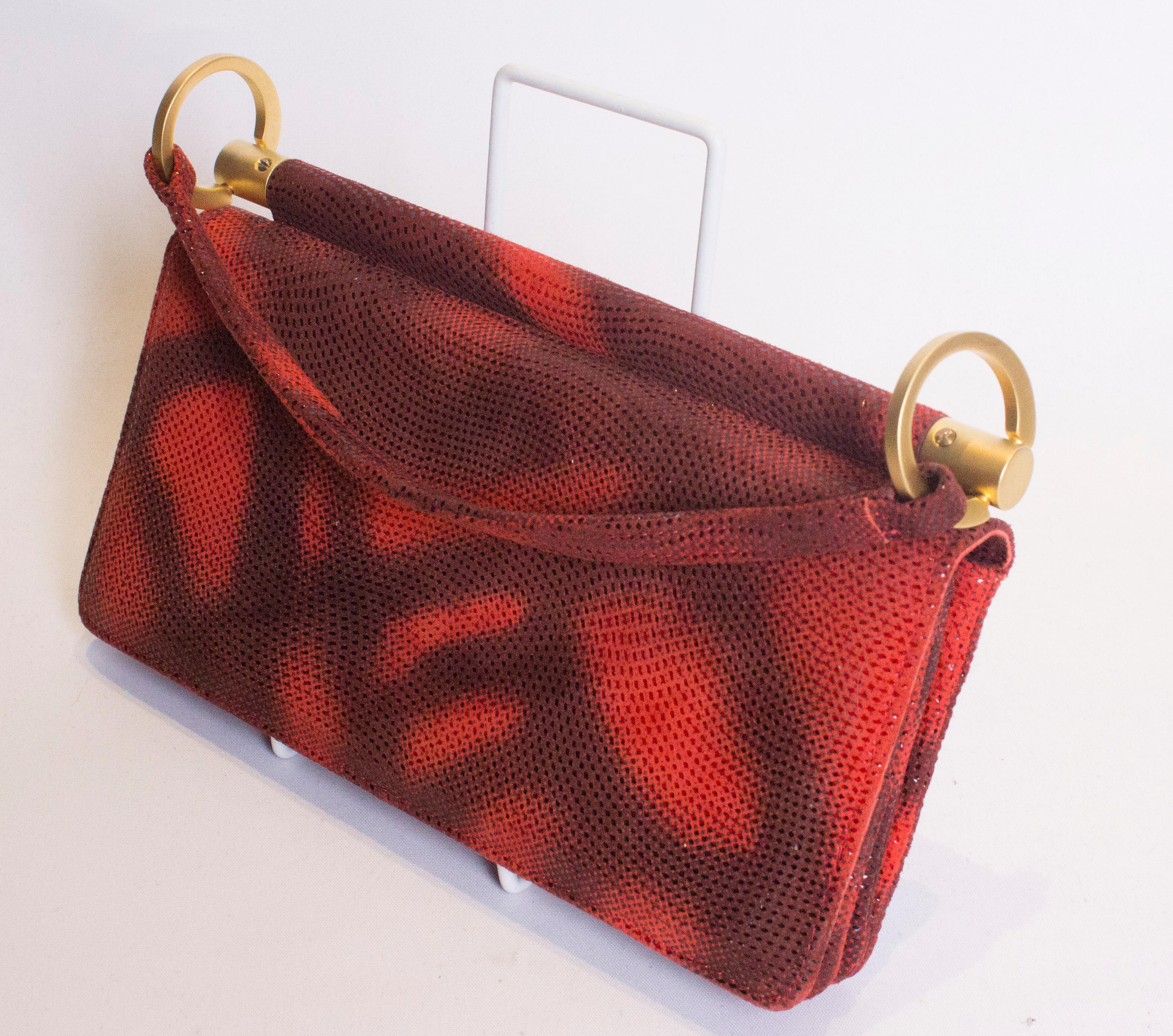 A chic vintage handbag by Charles Jourdan. The bag is in a wonderful red colour and has three internal compartments,each with a pouch pocket.  It has a flap over front and chic handle. Measurements: width 8 3/4/'', height 5'', depth 3''
