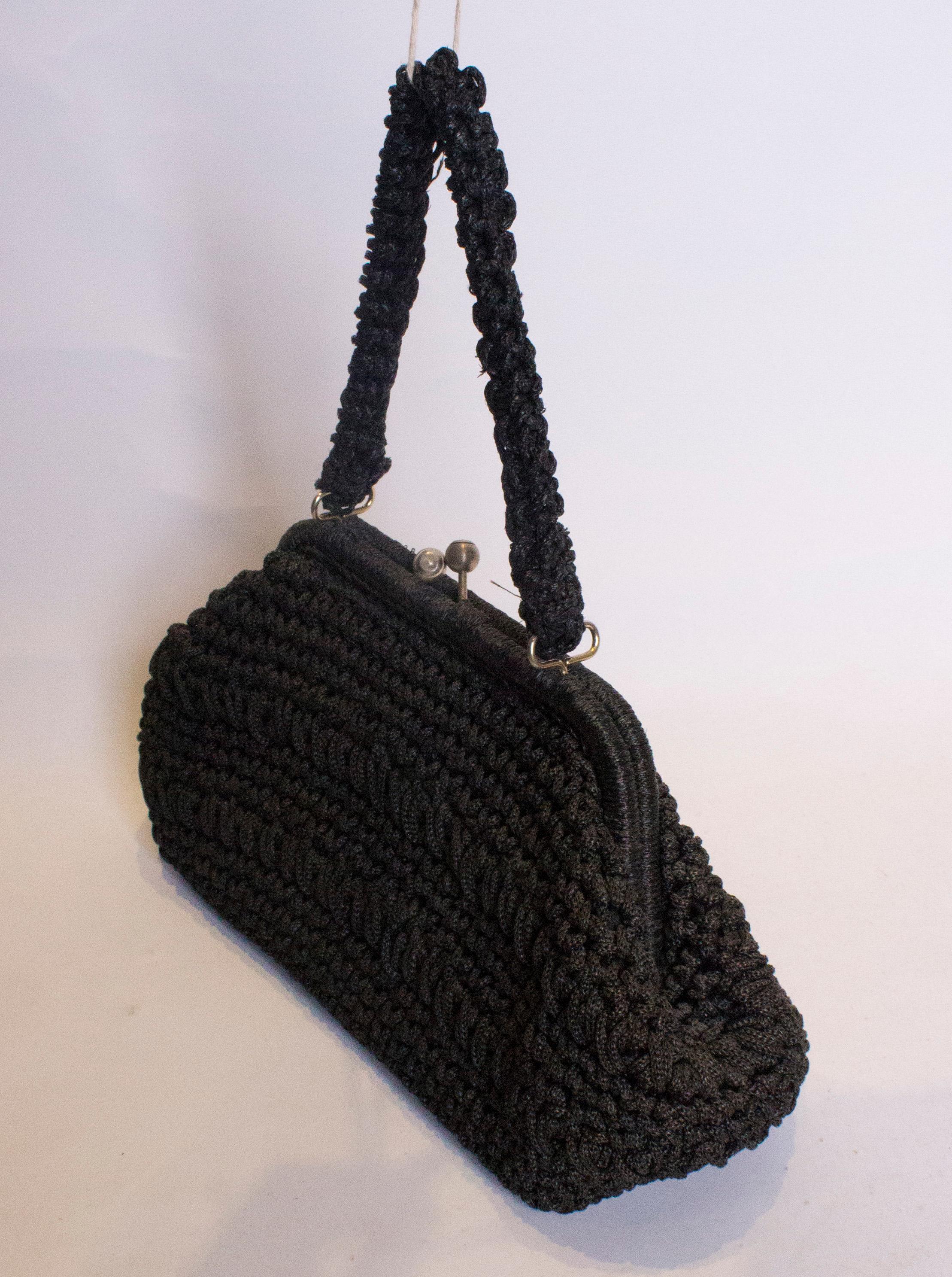 A chic vintage , black raffia bag. The bag has a central clasp and one internal pocket.
Measurements: width 14'', height 8'', depth 5''  