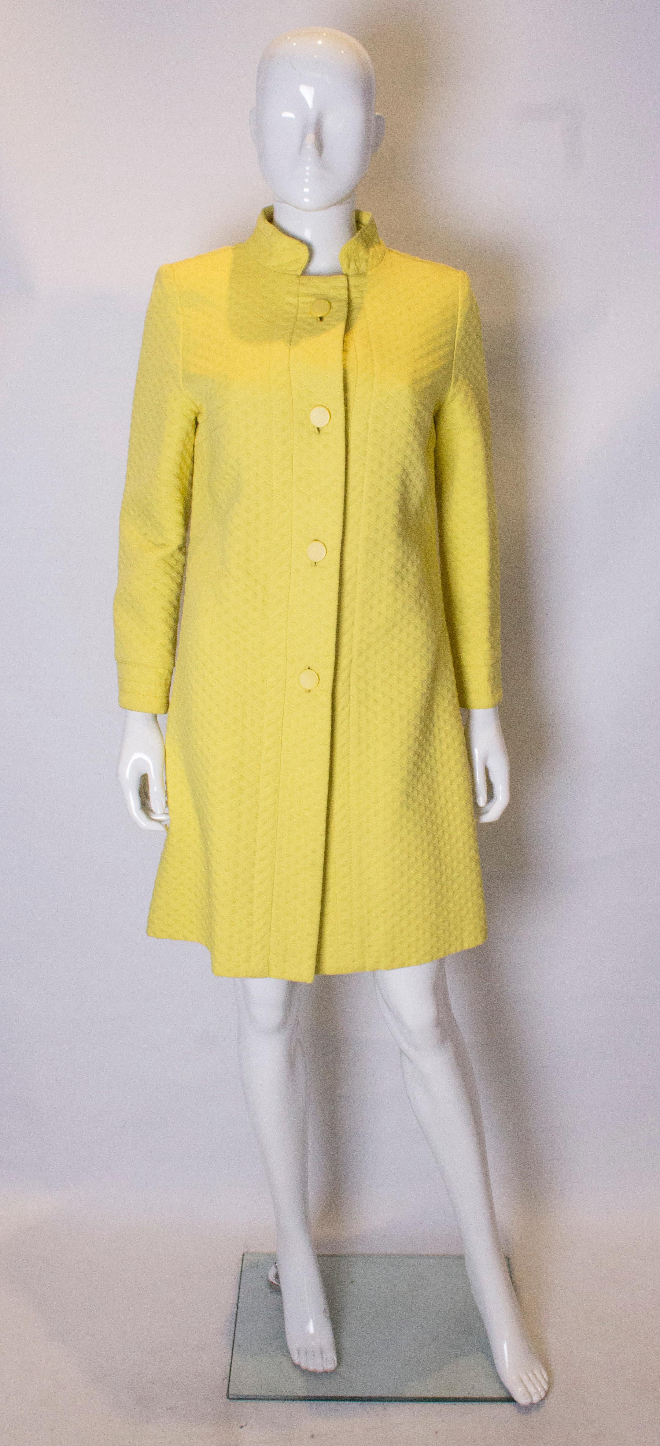 A headturning  chic vintage yellow coat. This quilted yellow coat has a mandarin collar with buttons detail on the cuffs ,and a button opening at the front. it has stitch detail on the shoulders and bust line.
