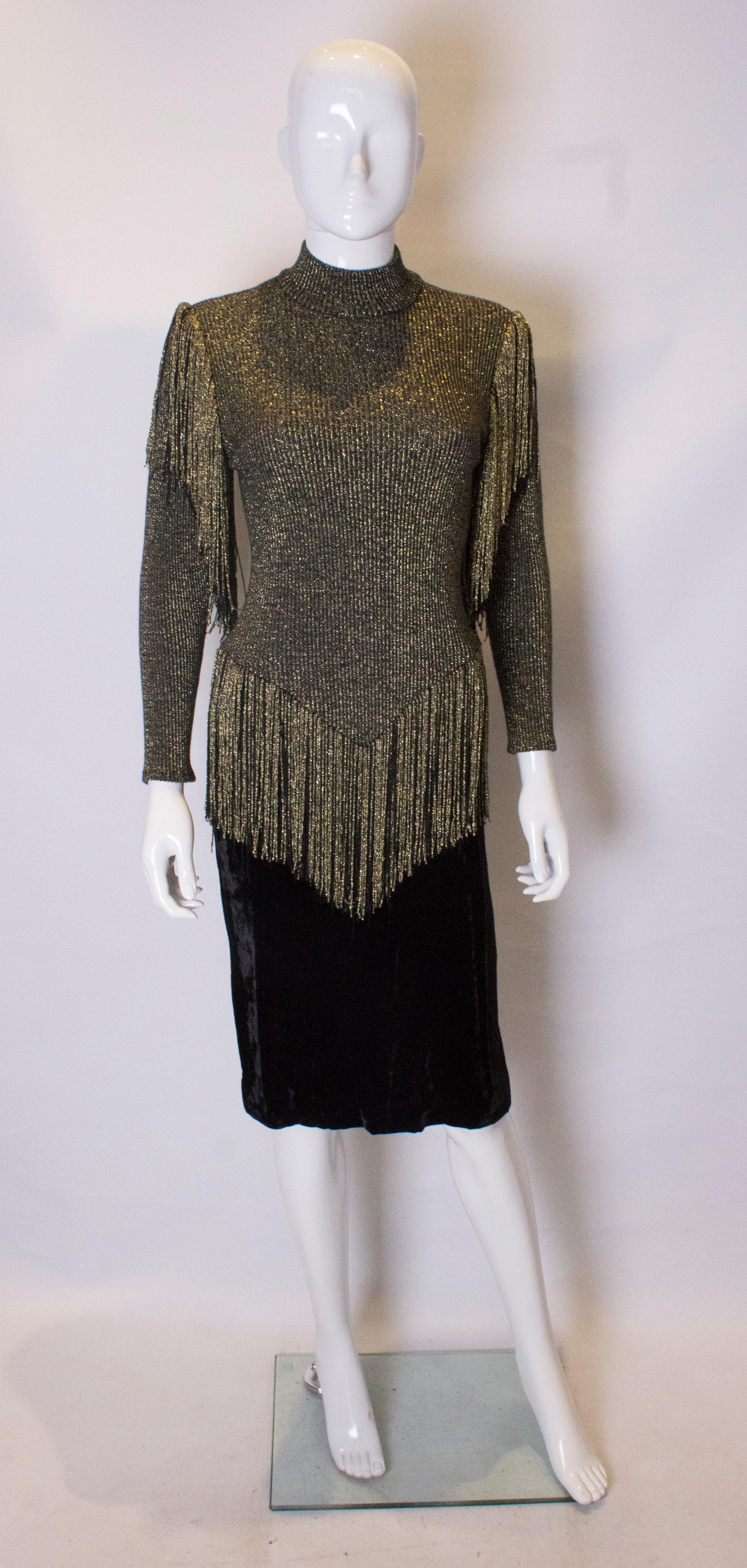 A great vintage party dress , with a black  and gold ribbed top , with turtle neck. There is black and gold fringing, on the shoulders and at dropped waist  leval. The lower part of the dress is black velvet.  