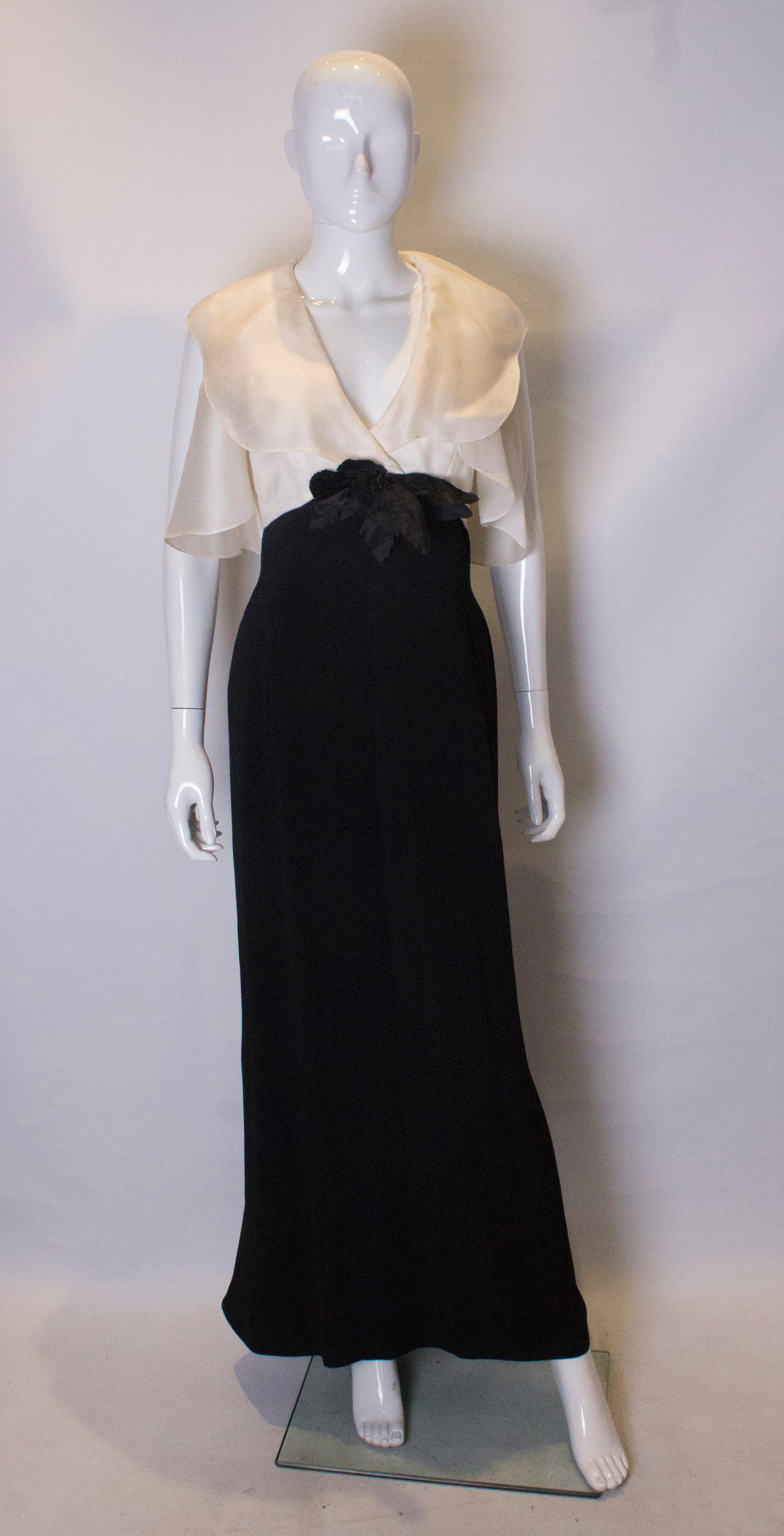 A chic vintage gown by Caroline Herrera. The dress has detachable cap sleaves in a woven silk. It has a white silk bodice , with a v neckline, and the body of the dress is black . The dress has a central back zip and is fully lined.