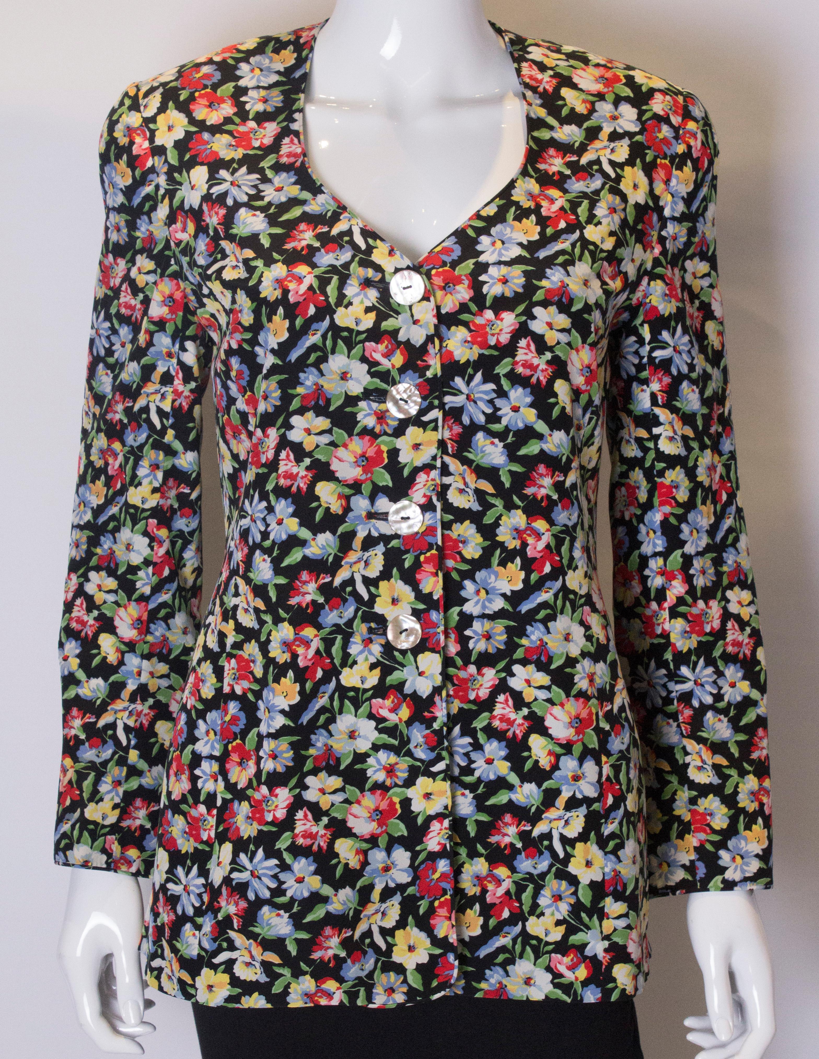 A chic floral silk jacket by Caroline Charles . The jacket has a v neckline with a four button opening It has interesting curved cuffs , and is fully lined.