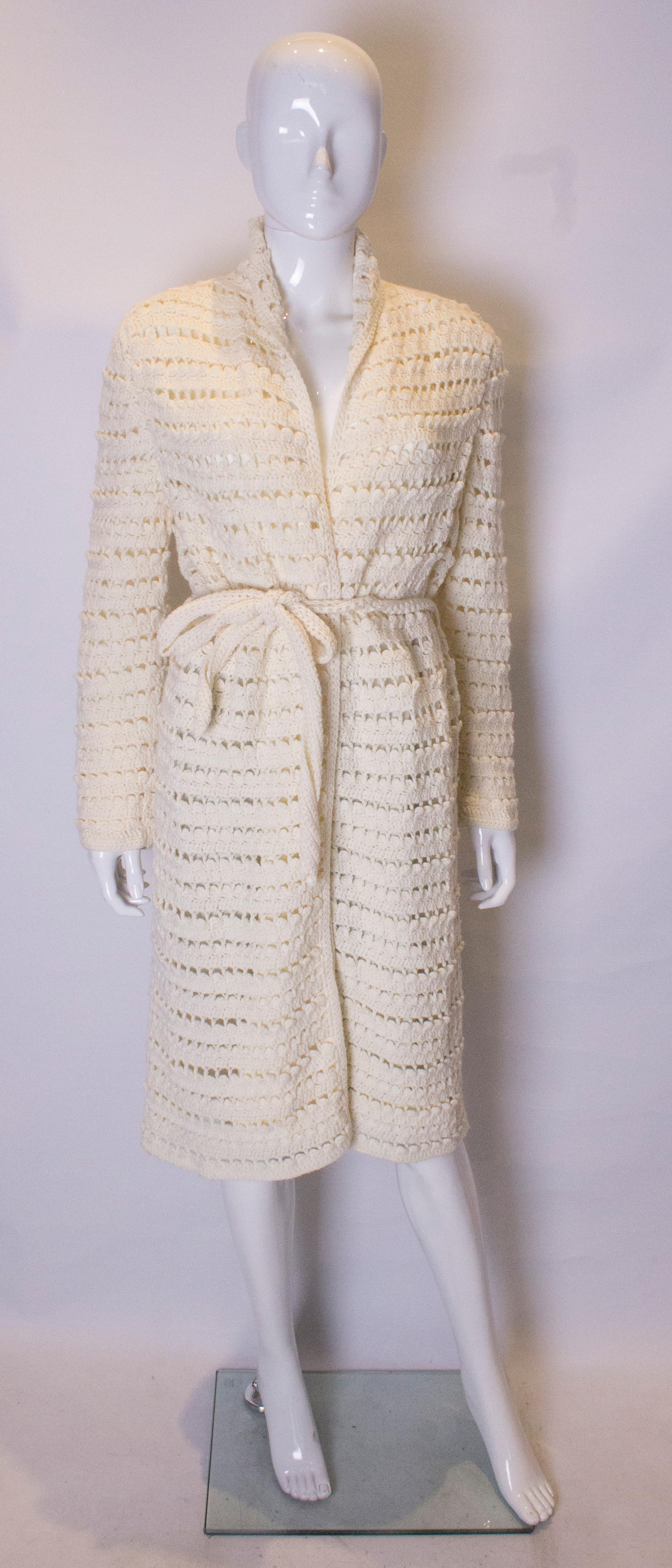 A chic knitted cream coat . The coat has a shawl collar, tie belt and is fully lined.