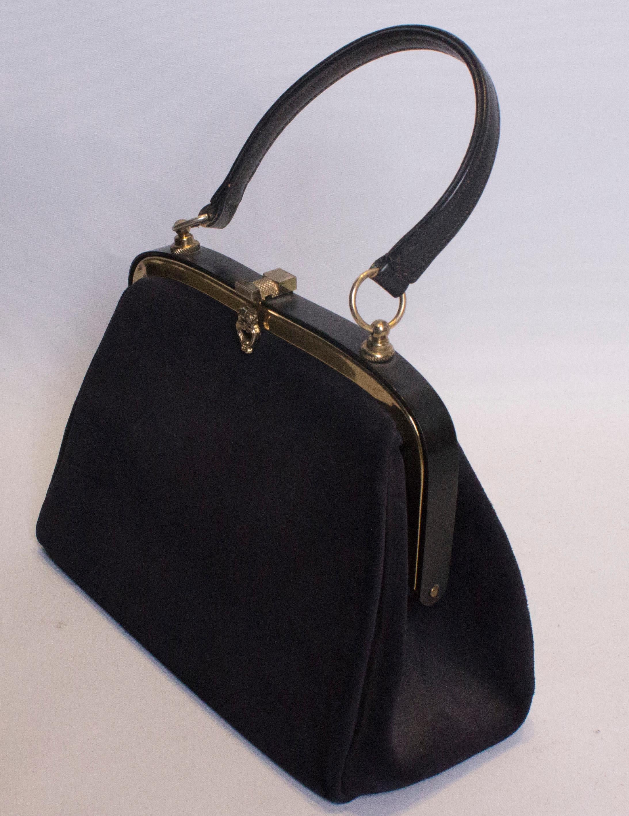 A chic top handle bag by Lederer for Russell and Bromley. The bag is in a nice dusty blue colour, with a central clasp and top handle. it has one internal zip pocket.