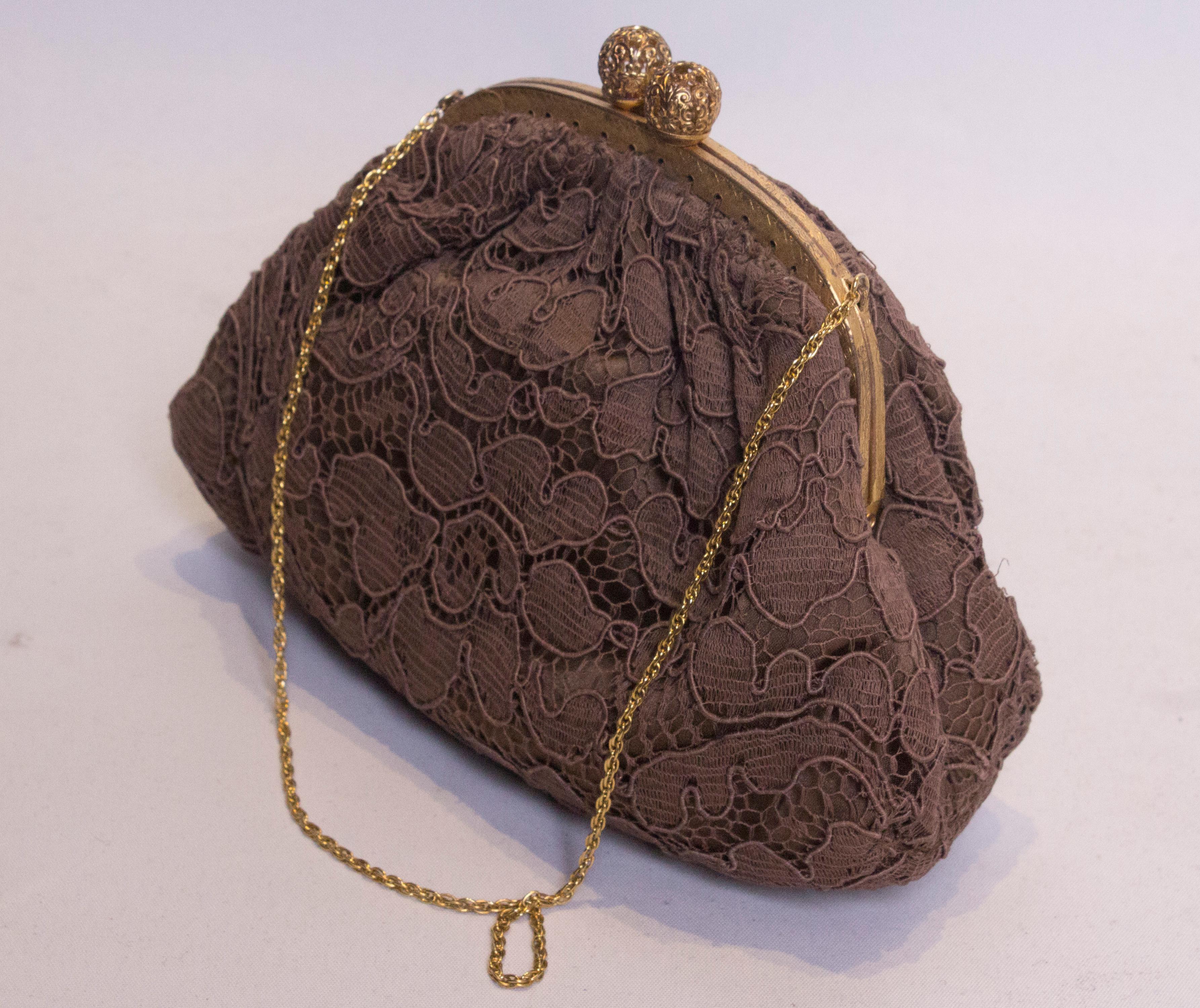 A pretty bag for an autumn evening. In brown lace this bag  has a two ball central clasp with a chain handle.  The bag is fully lined. 
