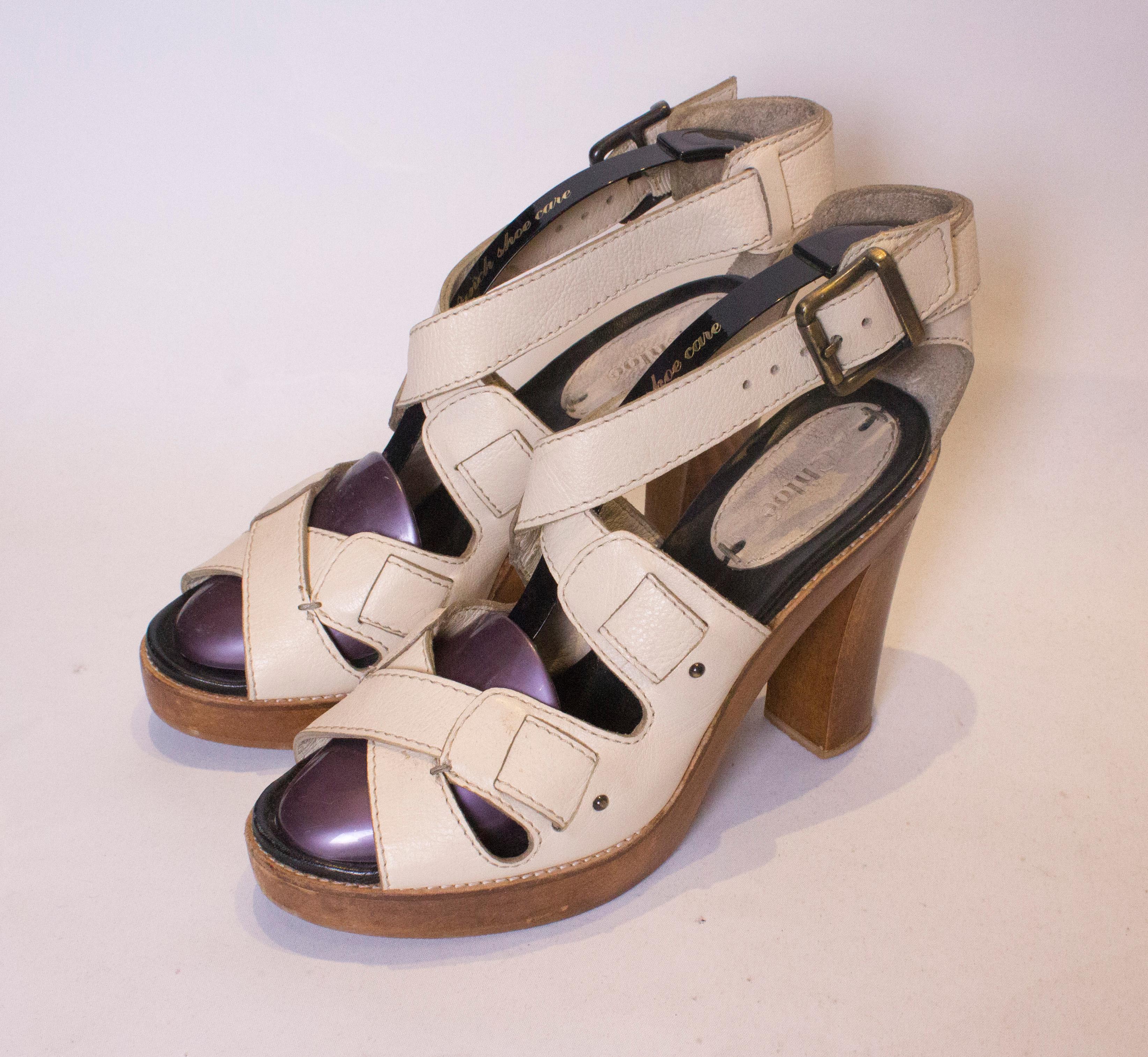 A great pair of leather sandles by Chloe. The sandles are ivory coloured leather with a wooden heel and platform.. They have a cross over front and another cross over near the ankle strap.  Size 39, heel height 5''