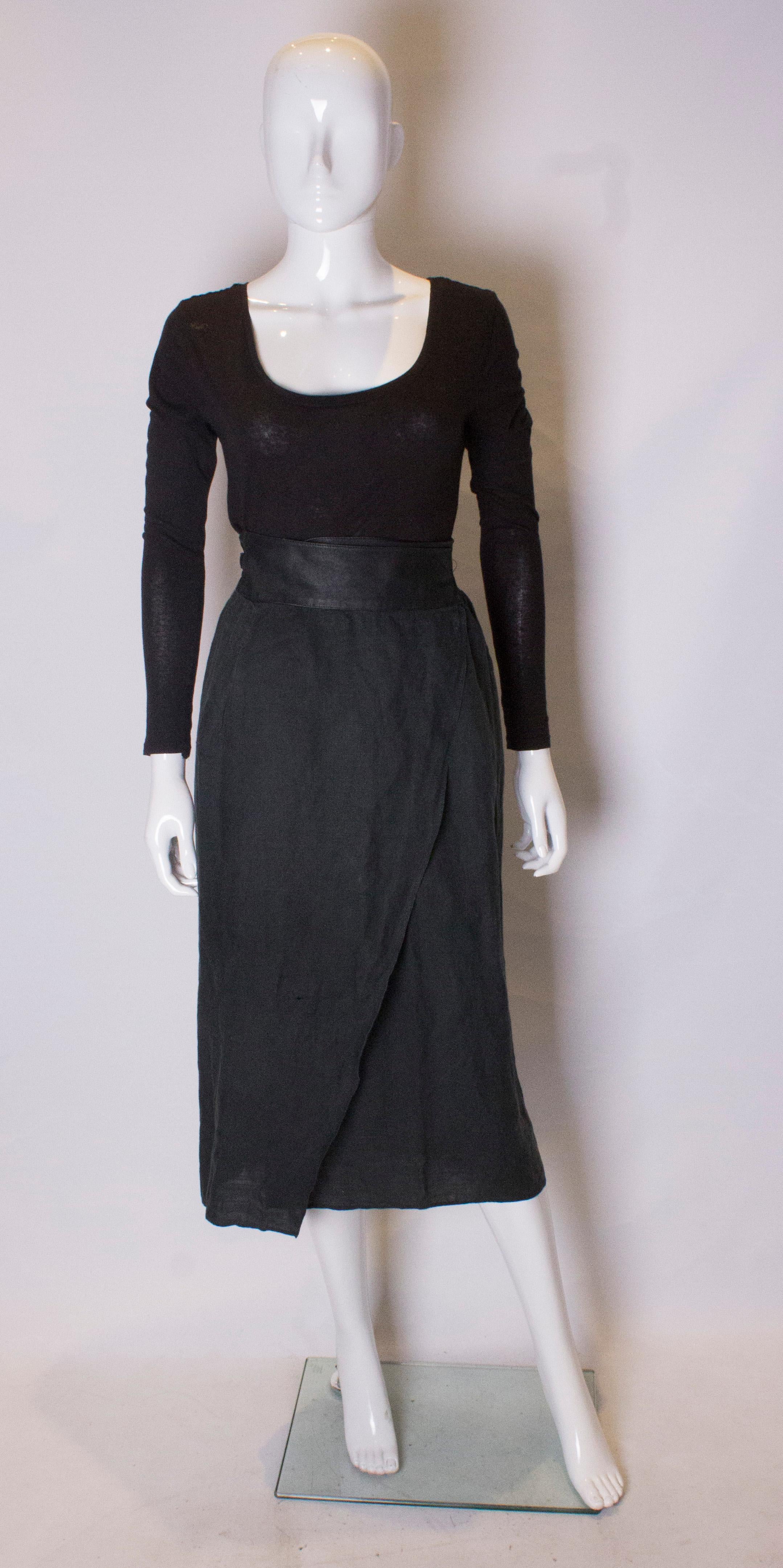 A chic vintage wrap around skirt by Versace mainline. The skirt has a leather waistband and tie, and skirt part is linen.