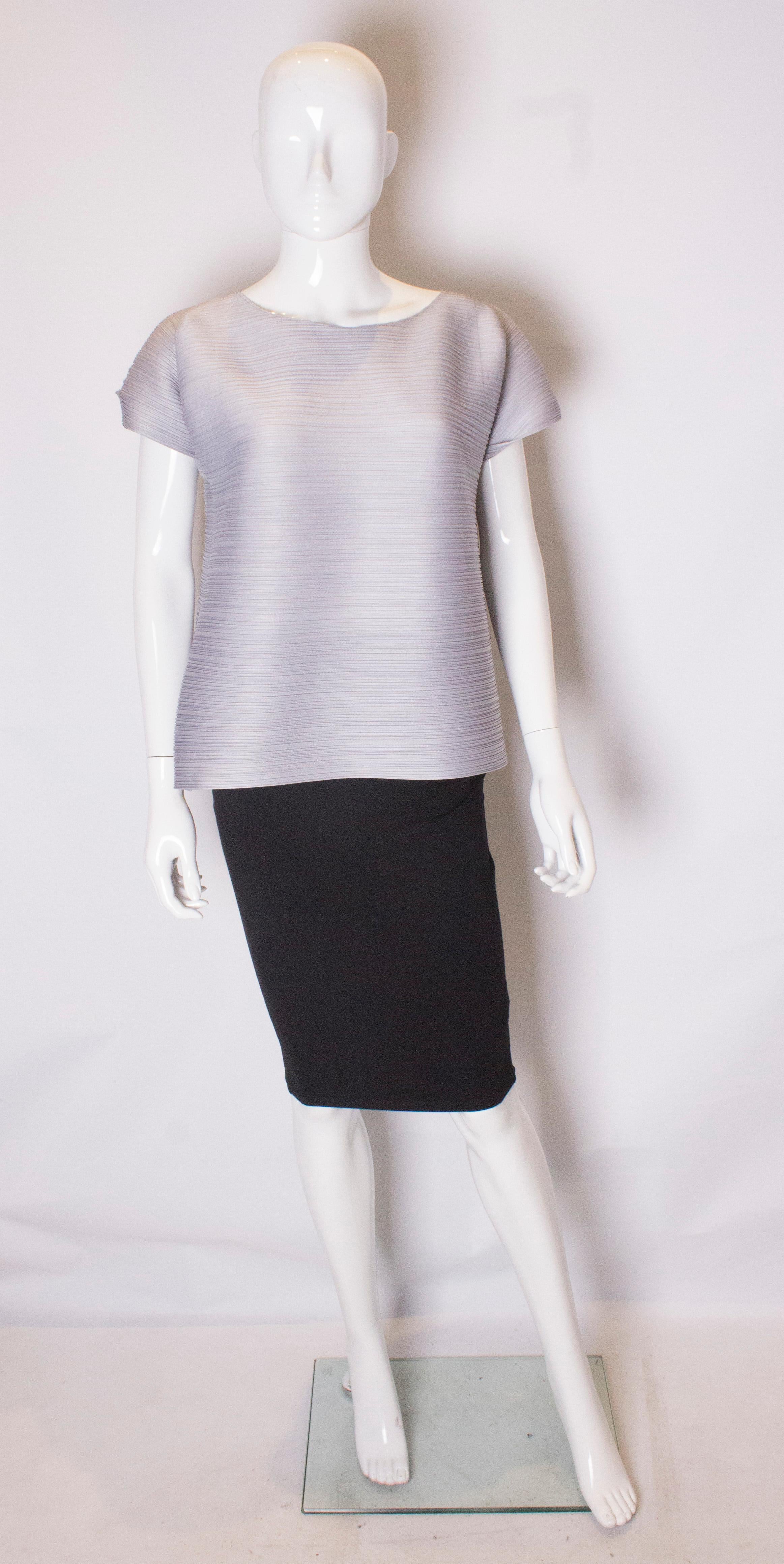 A great top by Issey Miyake, Pleats Please range. The top is in a pretty dove grey colour and has a round neck and cap like sleaves.