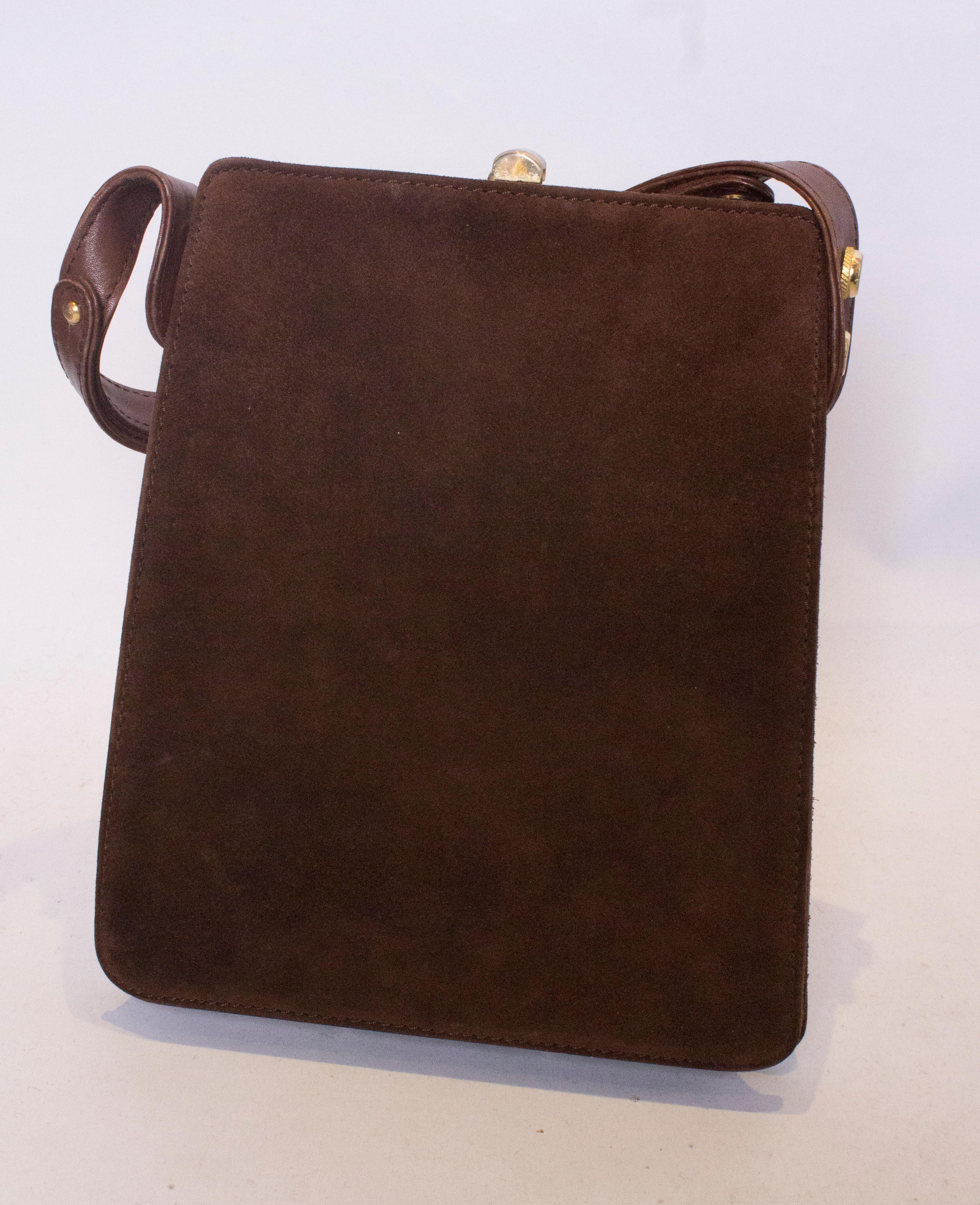 An elegant and interesting vintage handbag in brown leather and suede. The bag has an adjustable strap,and can be worn as a shoulder bag or hand bag.  The bag has a central top clasp, and internally there are two pouch pockets and a matching purse.