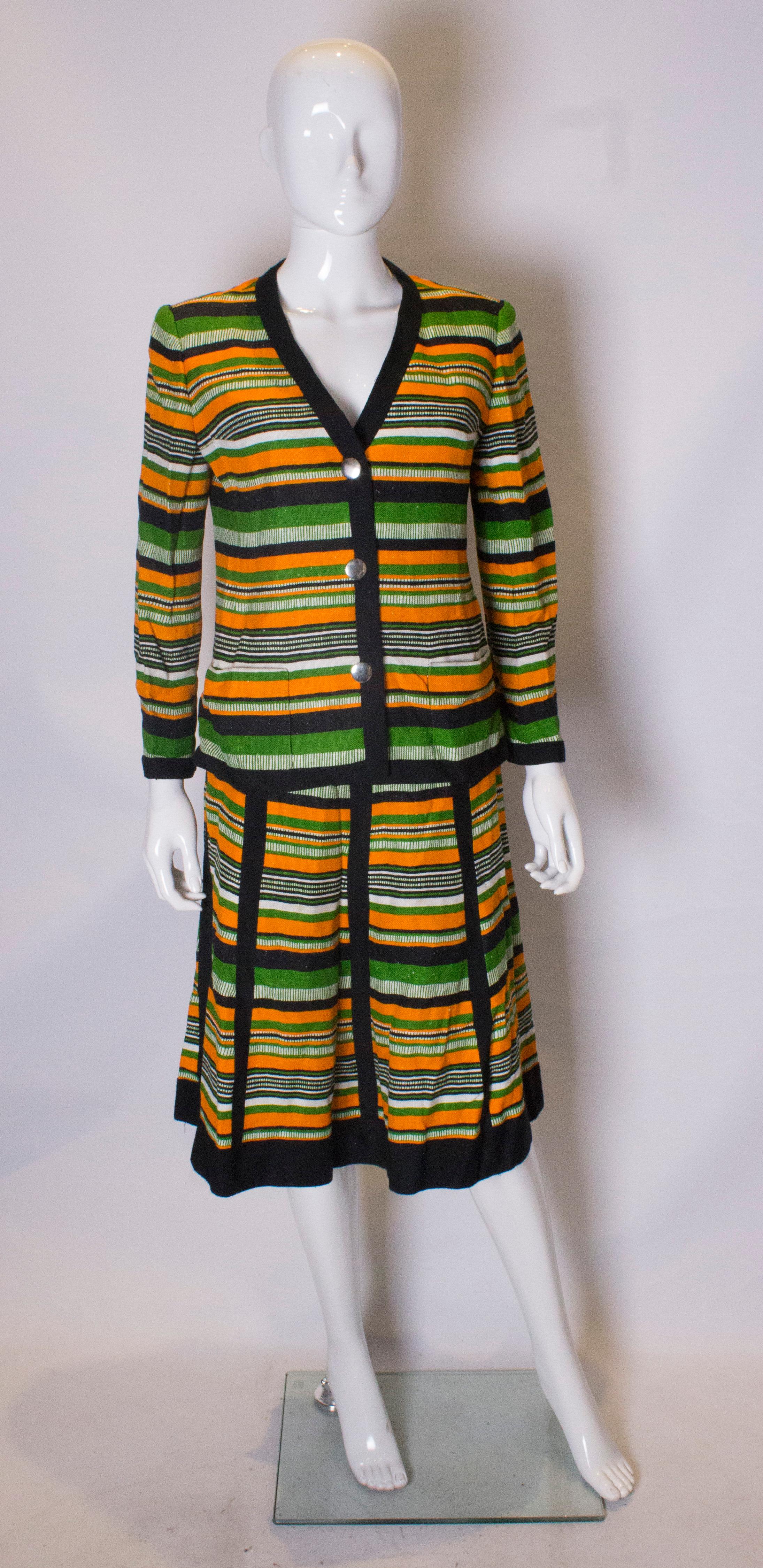 A chic skirt suit from the 1960s, by Parisian house Jacques Reval. The Jacket has a v neckline, two pockets and button front opening. The skirt has pleats that are sewn in until hip leval so producing a flattering line. Both jacket and skirt are