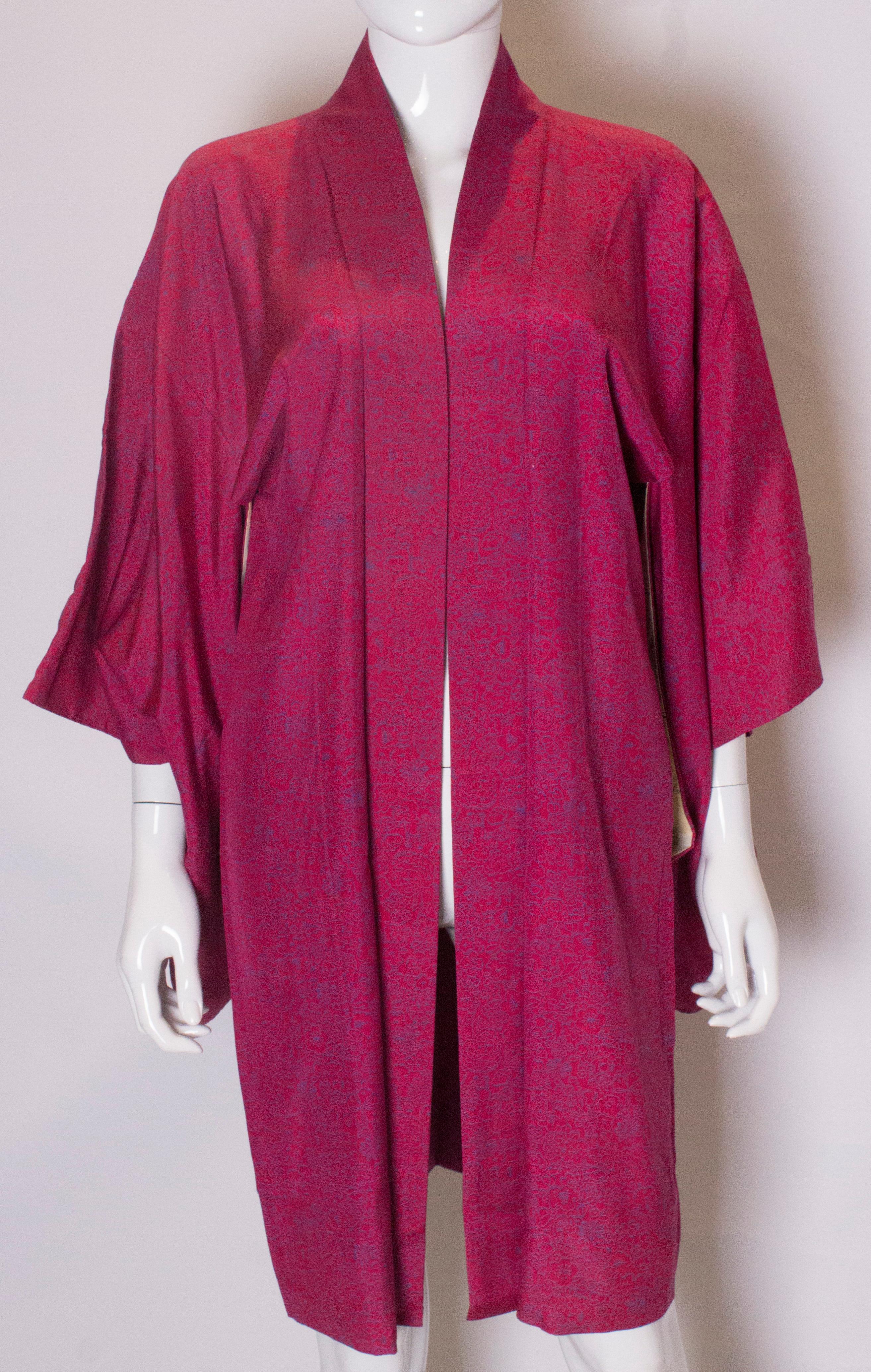 A chic pink vintage silk kimono. The  kimono is in a deep raspberry pink colour with a blue floral design. It is lined in silk. 
Measurements bust up to 40'',length 38''