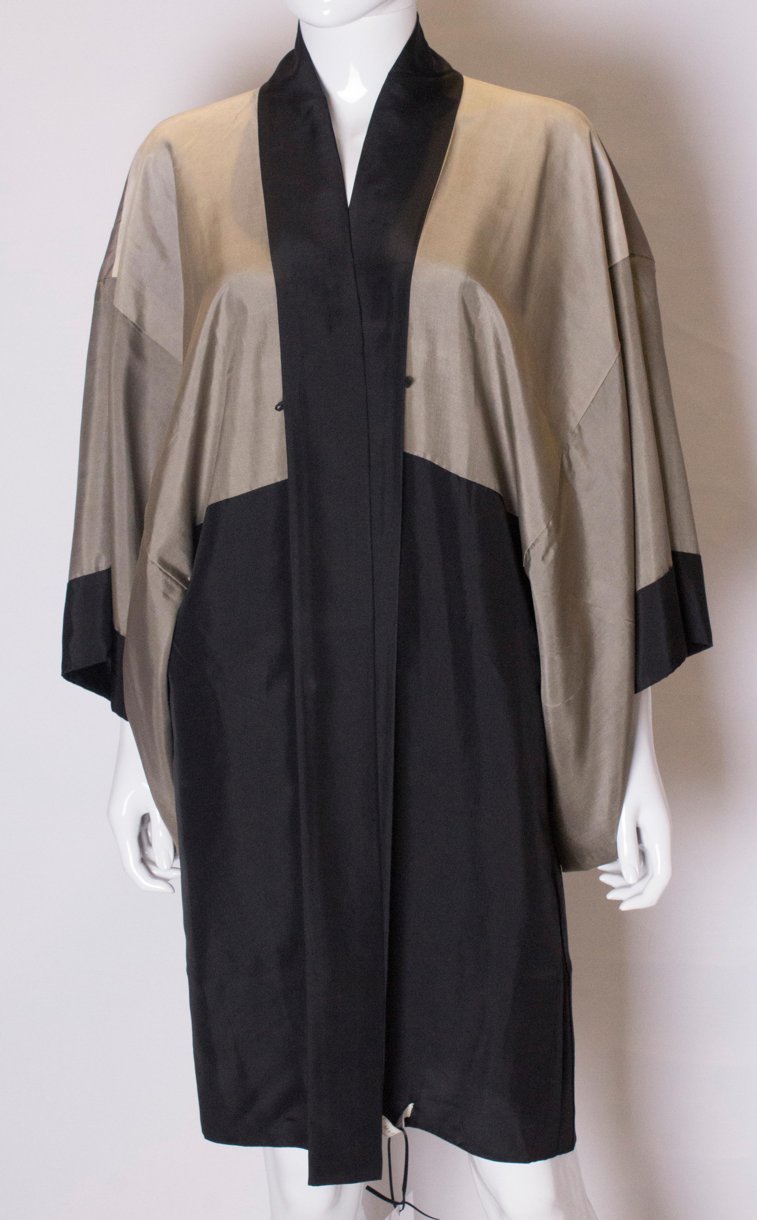 A chic vintage silk kimono.  The kimono is reversible and can be worn in two ways,one version is the plain black with white circular print, the other is with the hand painted picture of the tiger on the outside.
Measurements; Bust up to 40'', length