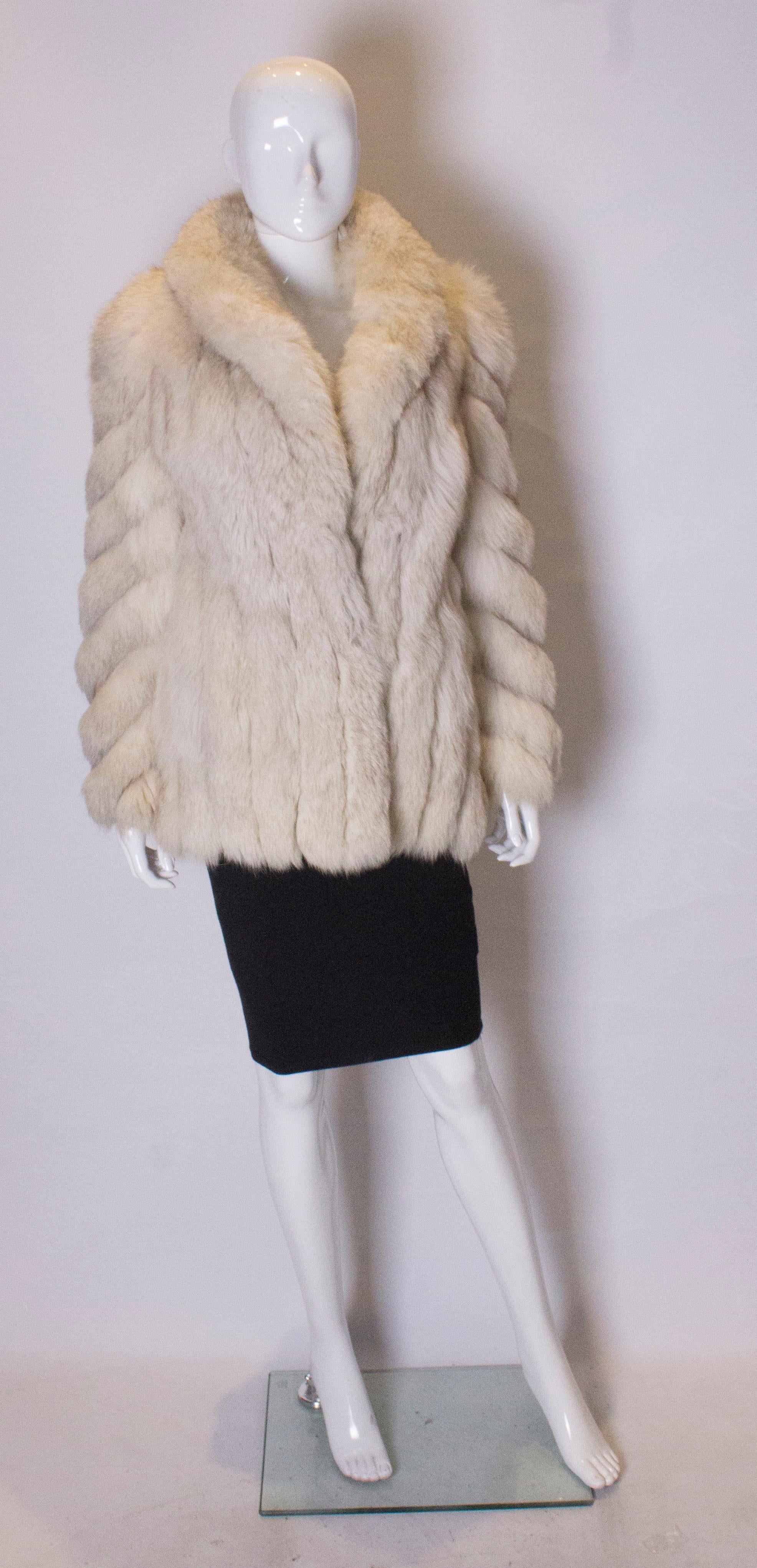 A vintage 1970s artic white fox fur pelted jacket winter coat with two pockets and fastens with two hooks on the front

a UK 8 size small